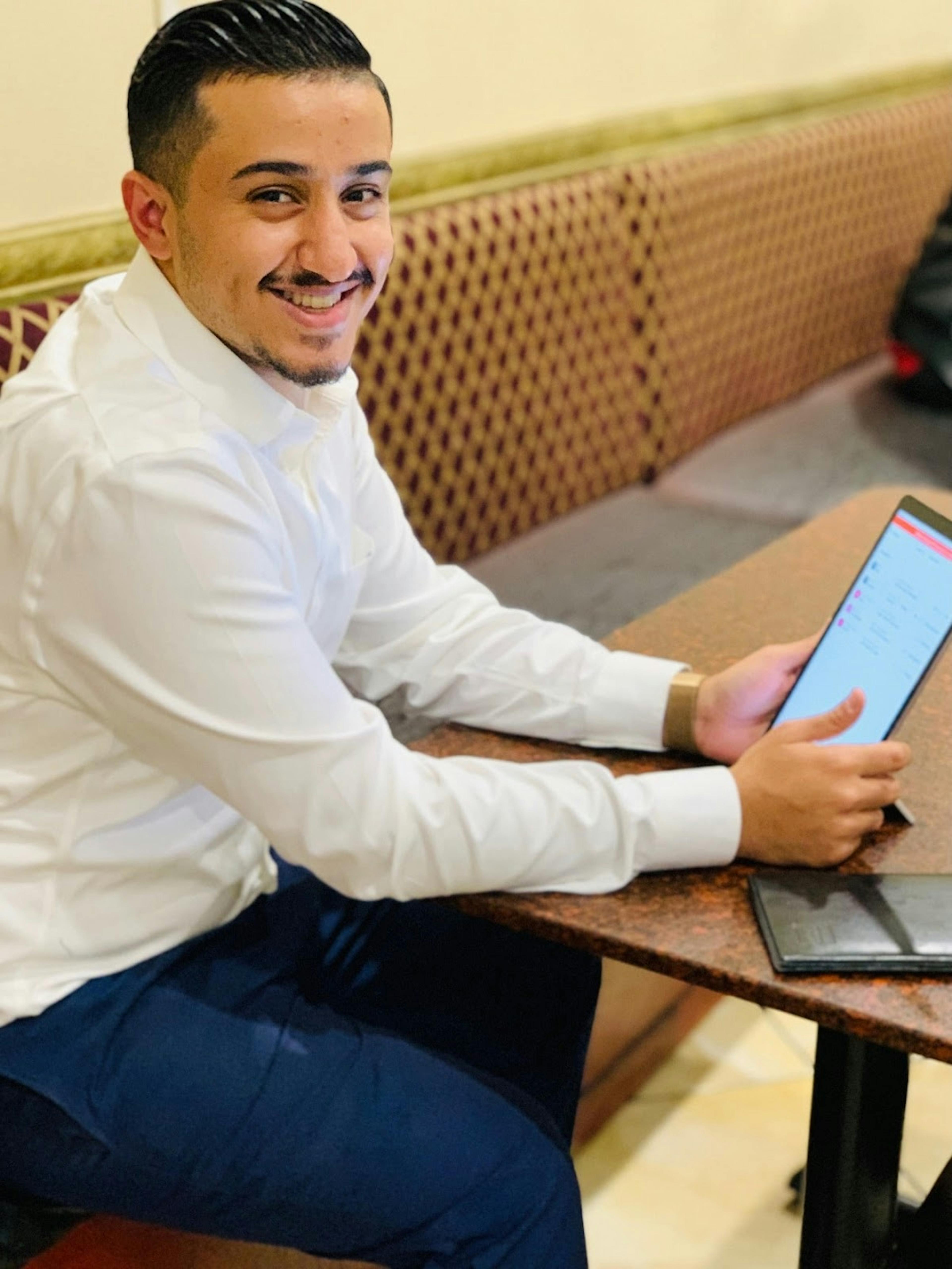 Image of Ali Alsubai, owner of Yemen Cafe in New York, working on his Otter tablet