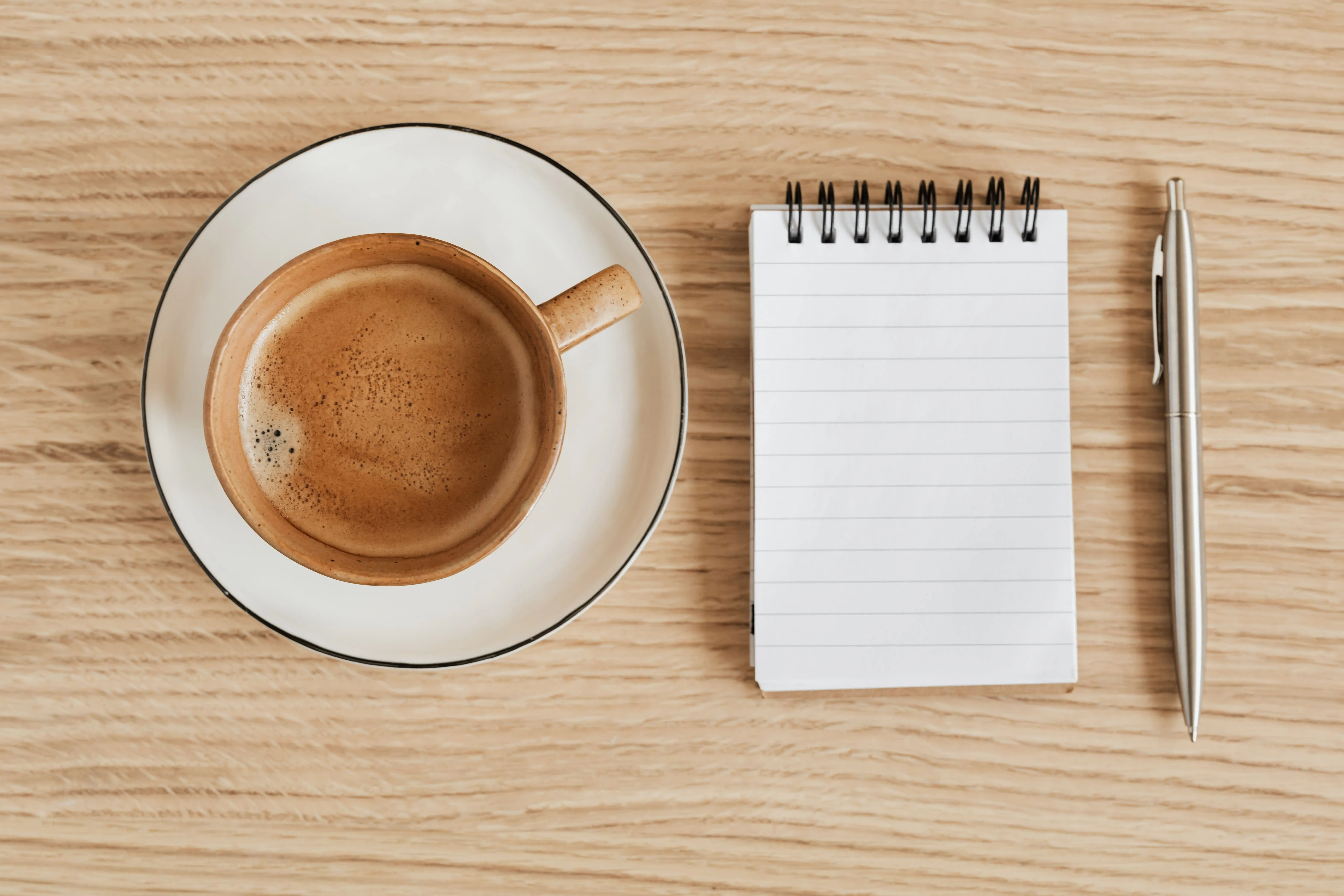 Coffee shop overhead shot of espresso and notebook.