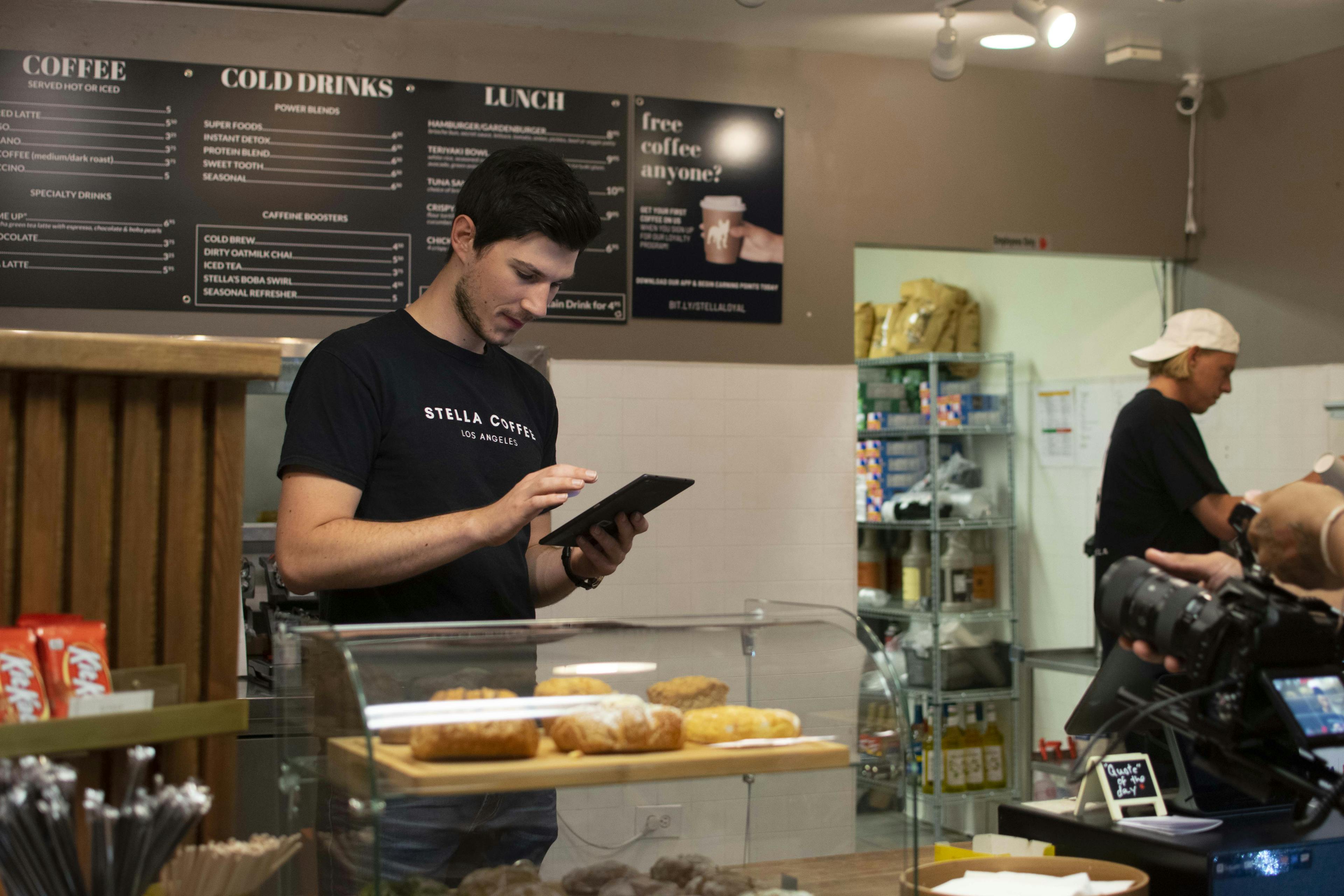 Stella Coffee employee using Otter tablet at cafe. 