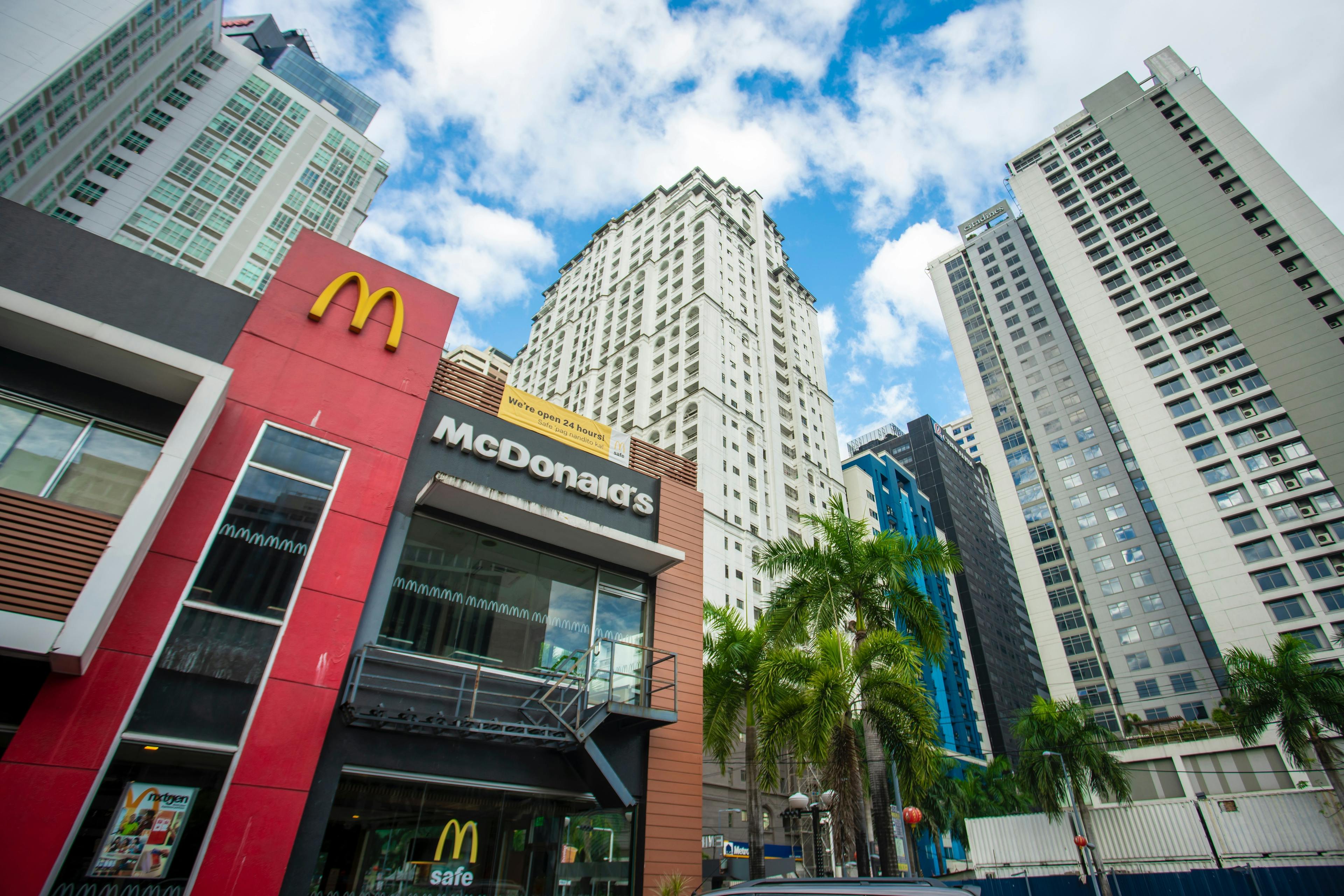 McDonalds franchise located next to skyscraper buildings. 