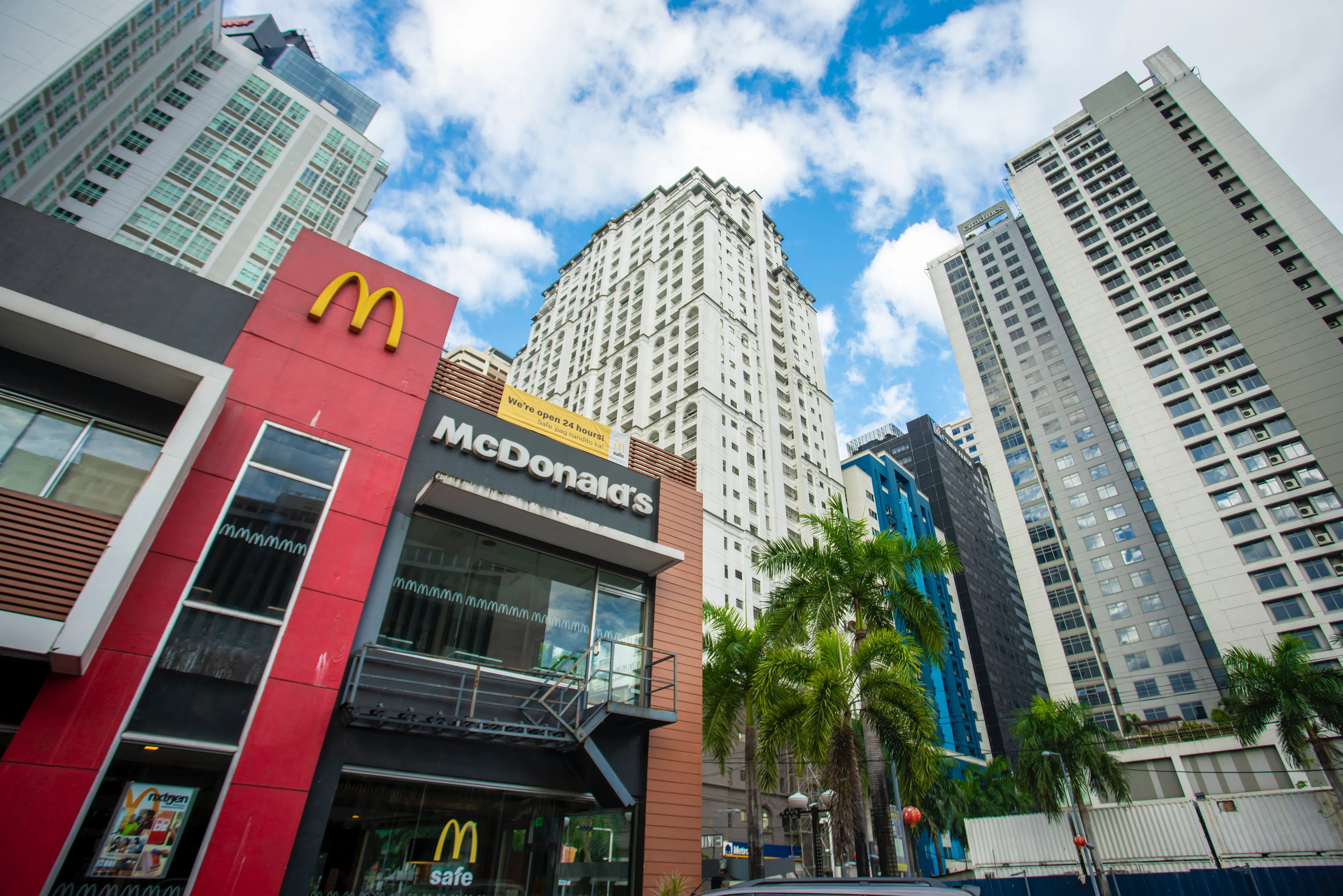 McDonalds franchise located next to skyscraper buildings.