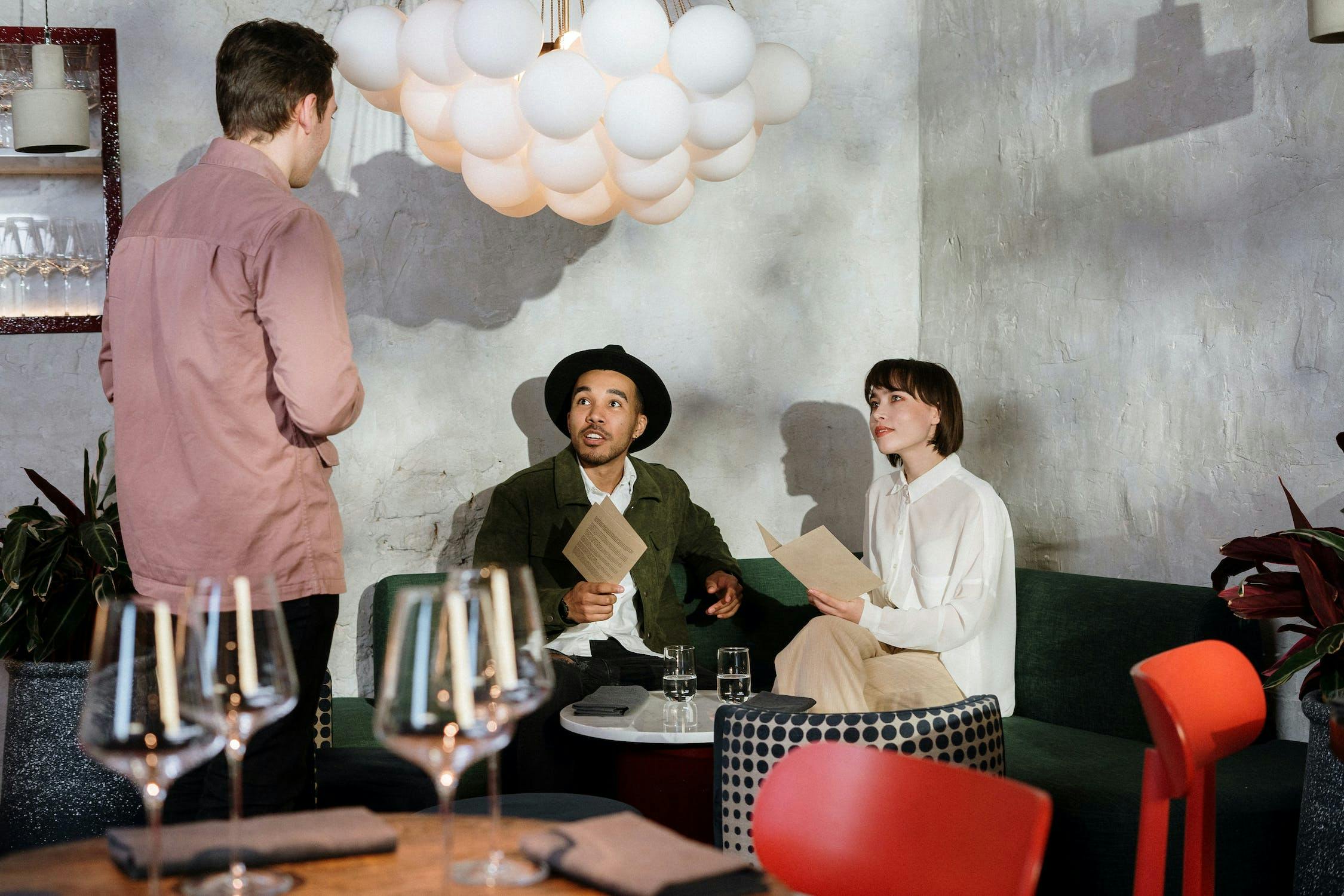 Customers ordering from menu in trendy restaurant.