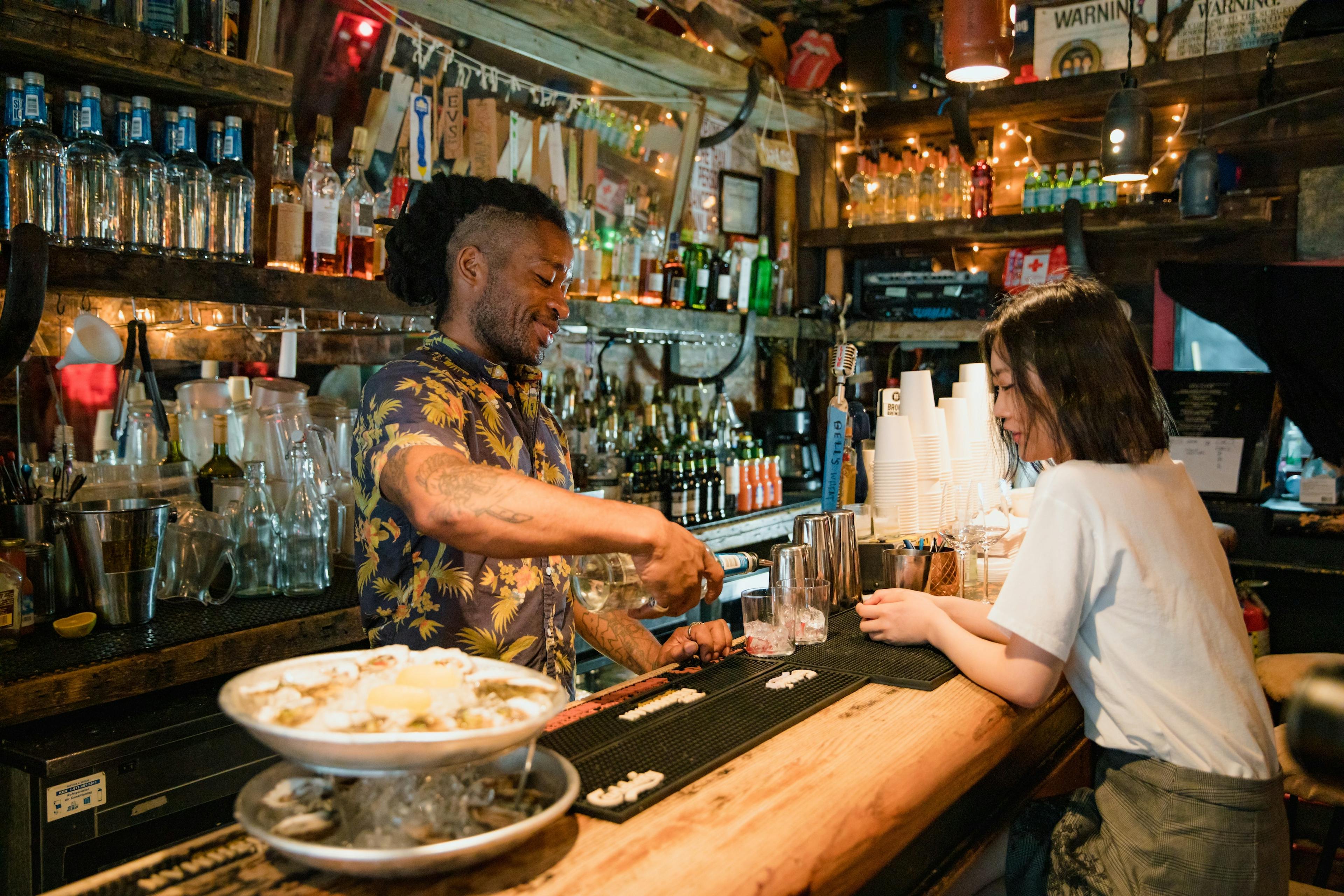 Image of a bartender preparing a drink for a guest