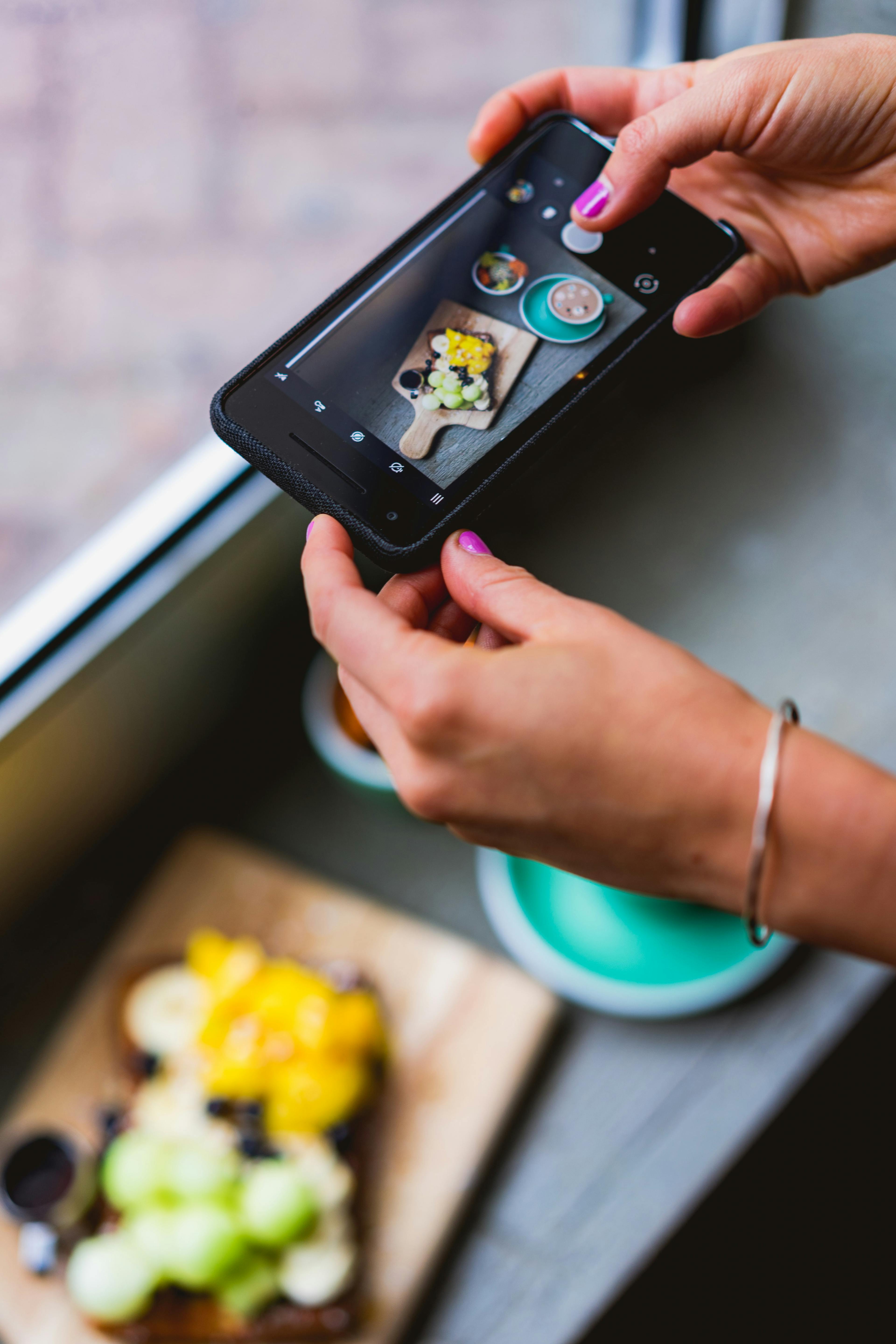 Image of someone taking a photo of their food on an iPhone