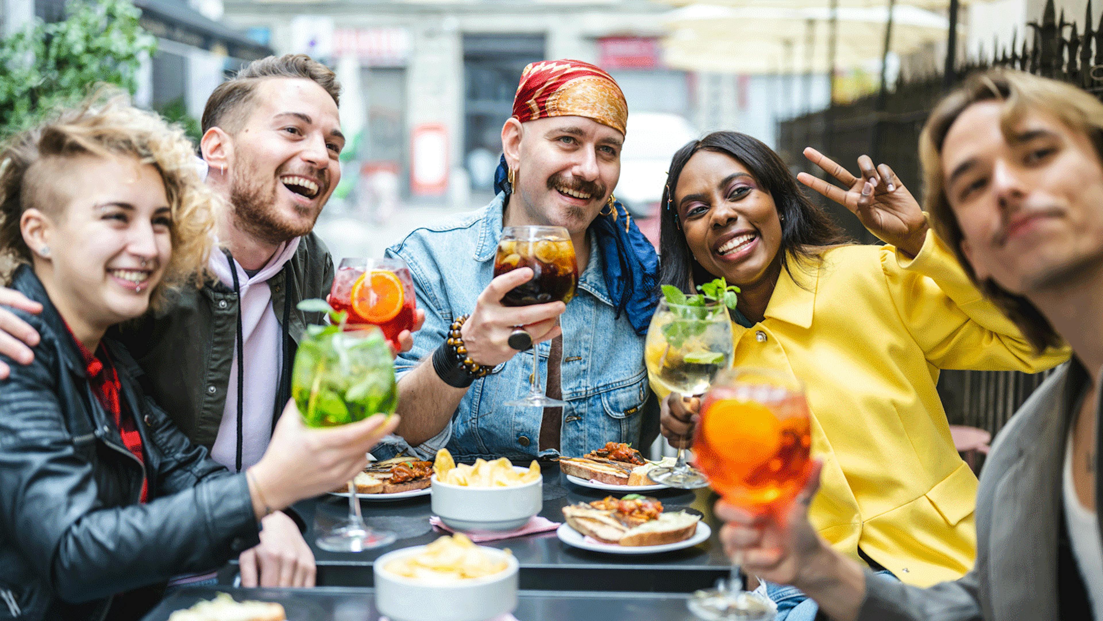 Image of a diverse group of friends celebrating Pride month at a restaurant