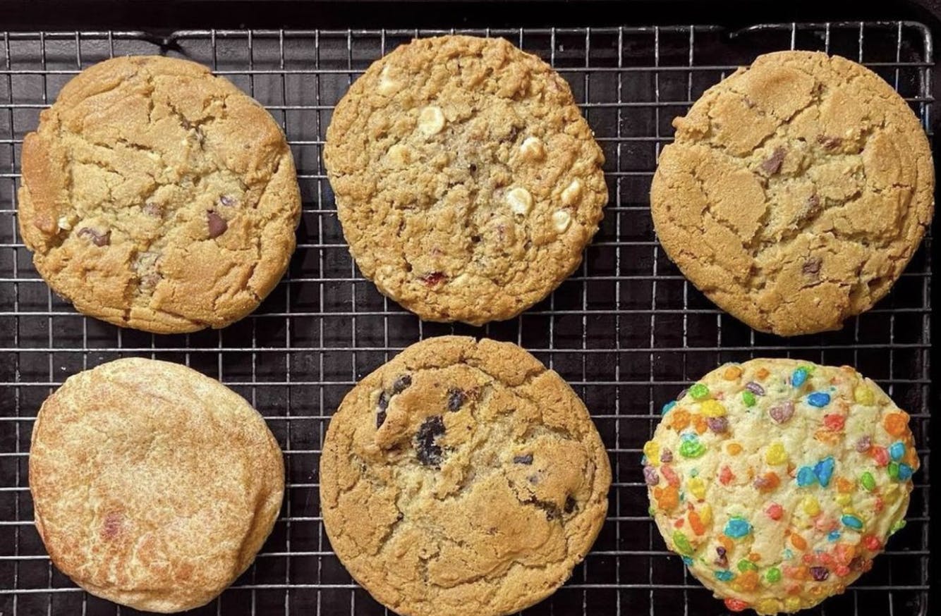 Image of six Midnight Cookie Co cookies on a baking sheet