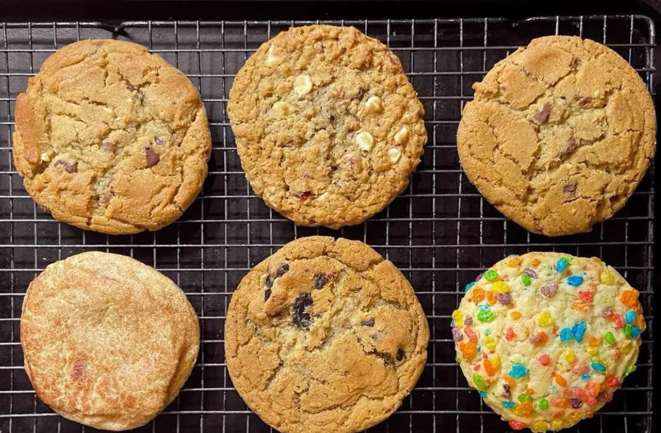 Image of six Midnight Cookie Co cookies on a baking sheet