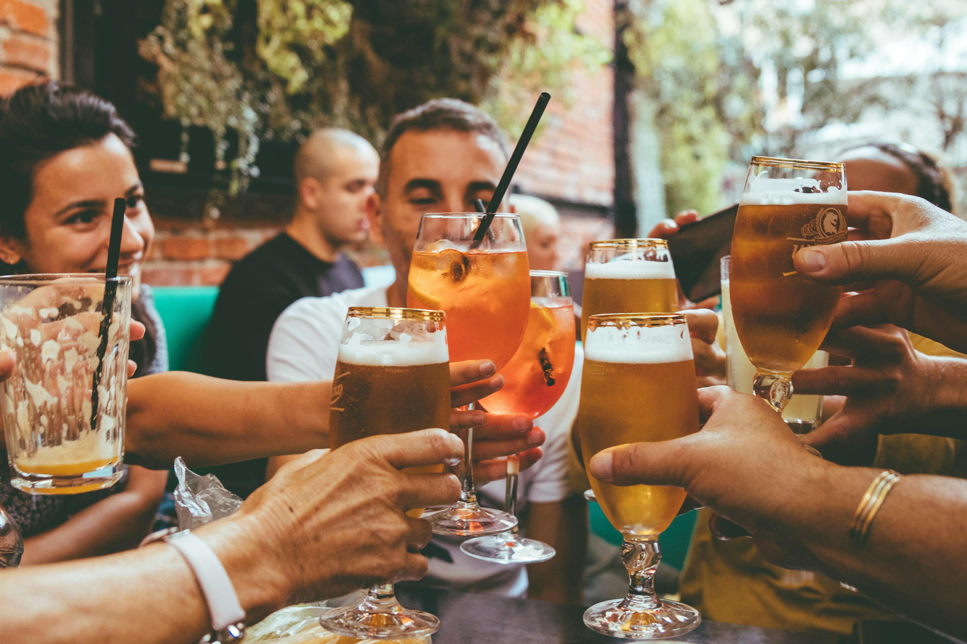 Image of group of friends cheersing cocktails at a patio bar