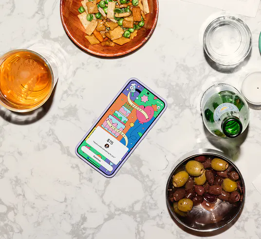 A phone surrounded by drinks and snacks.