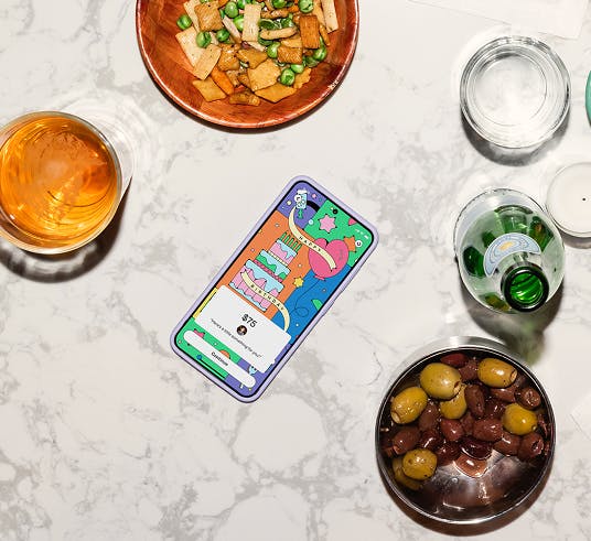 A phone surrounded by drinks and snacks.