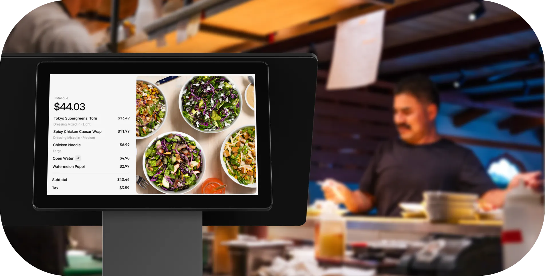 Restaurant staff using a POS system to manage orders at a fast-casual restaurant counter