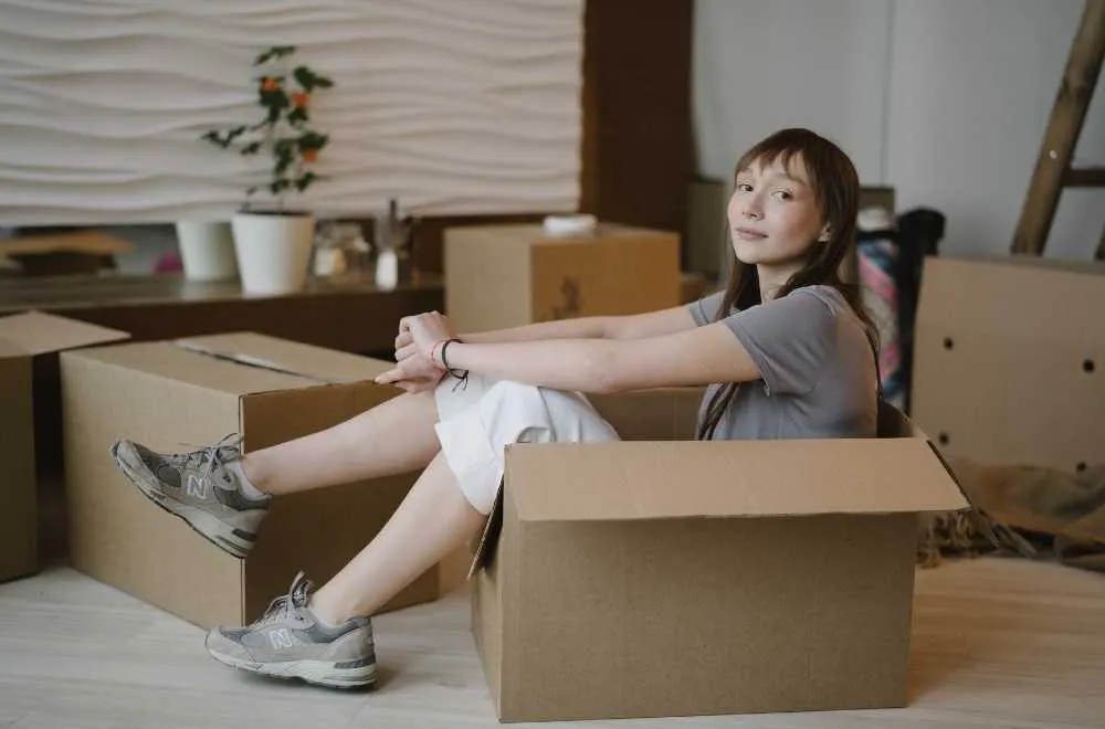 femme au milieu des cartons pendant son déménagement