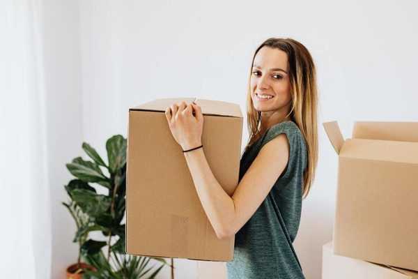 femme qui porte un carton