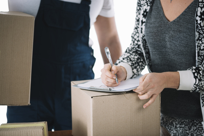 Une femme signant un document sur un carton 