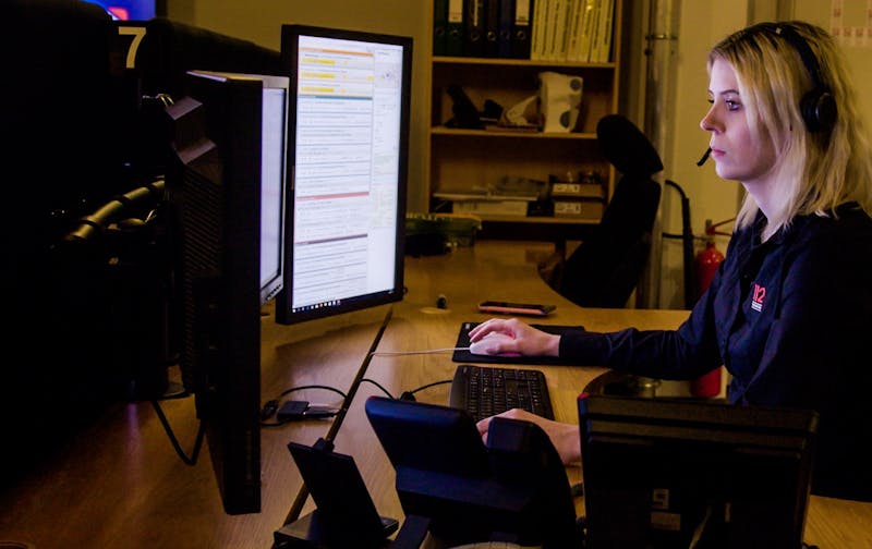 Neyðarvörður við skrifborðið sitt þar sem á eru margir símar og skjáir