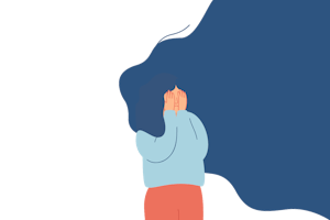 A woman covers her face with her hands.
