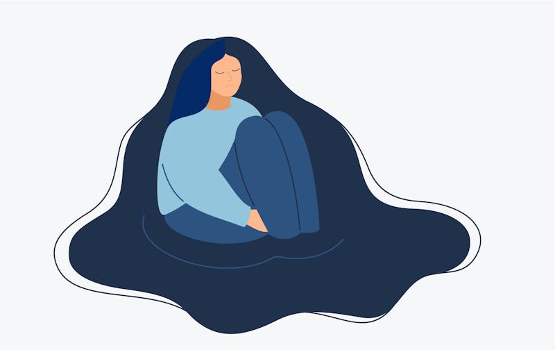 A woman sits on the floor, surrounded by her hair.