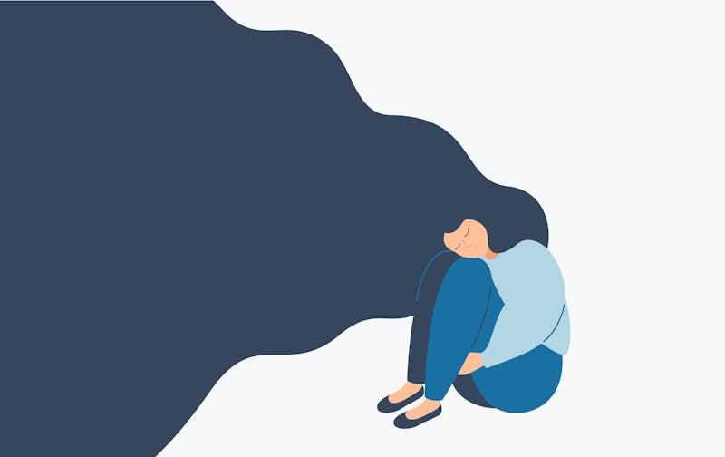 Kobieta o falowanych włosach siedzi samotnie na podłodze.