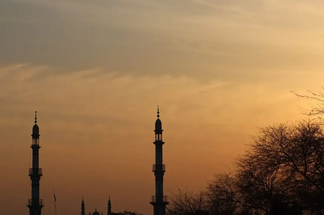 Siluet menara masjid saat senja, ilustrasi untuk artikel "Ikhtishar 'Ulumil Hadits Bab 11: Hadits Munqathi'"