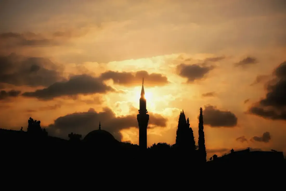 Siluet menara masjid saat senja, ilustrasi untuk artikel "Muqaddimah Ibnu Shalah Bab 66: Wathan (Tanah Air) Para Perawi"