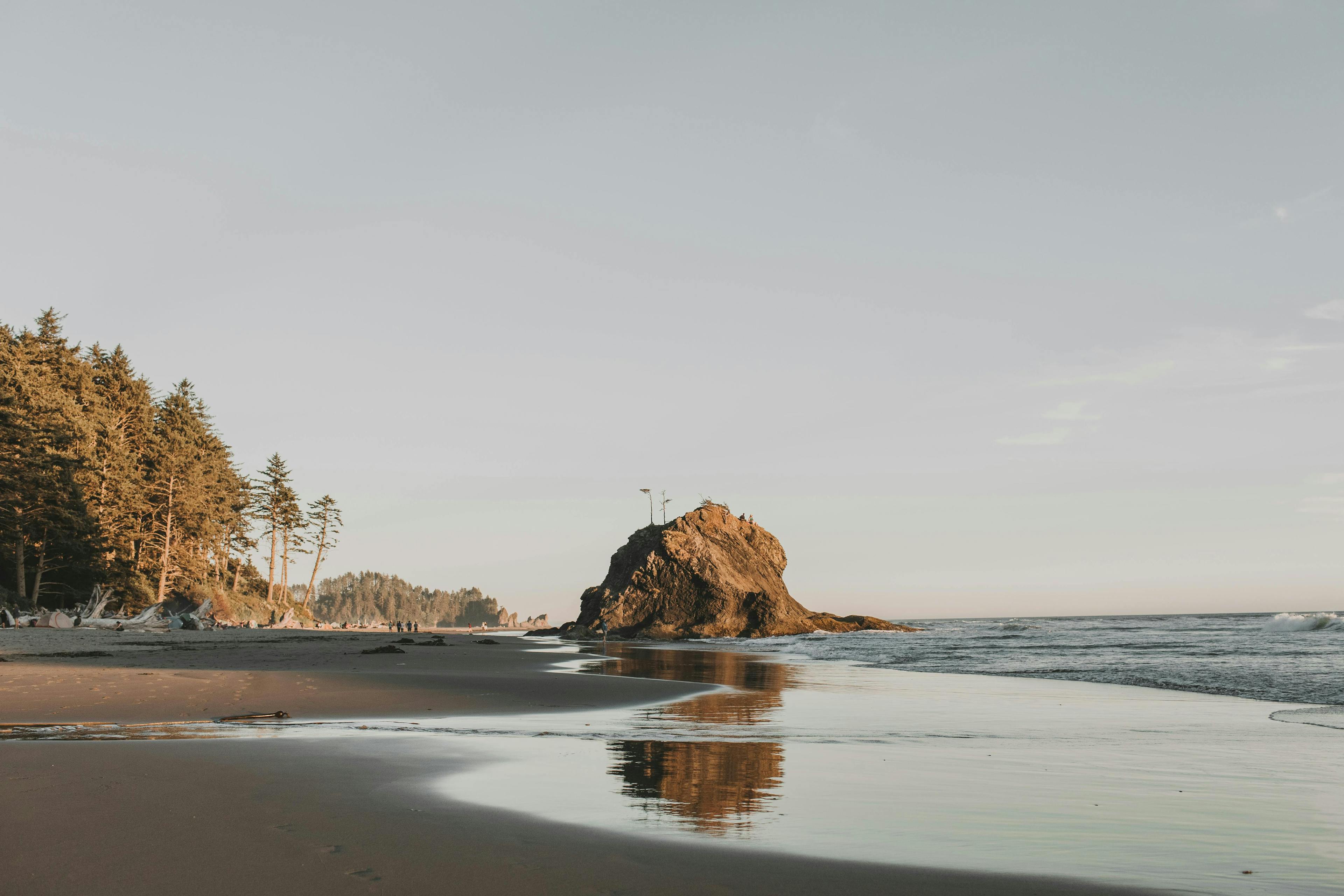 A beach with a large rock