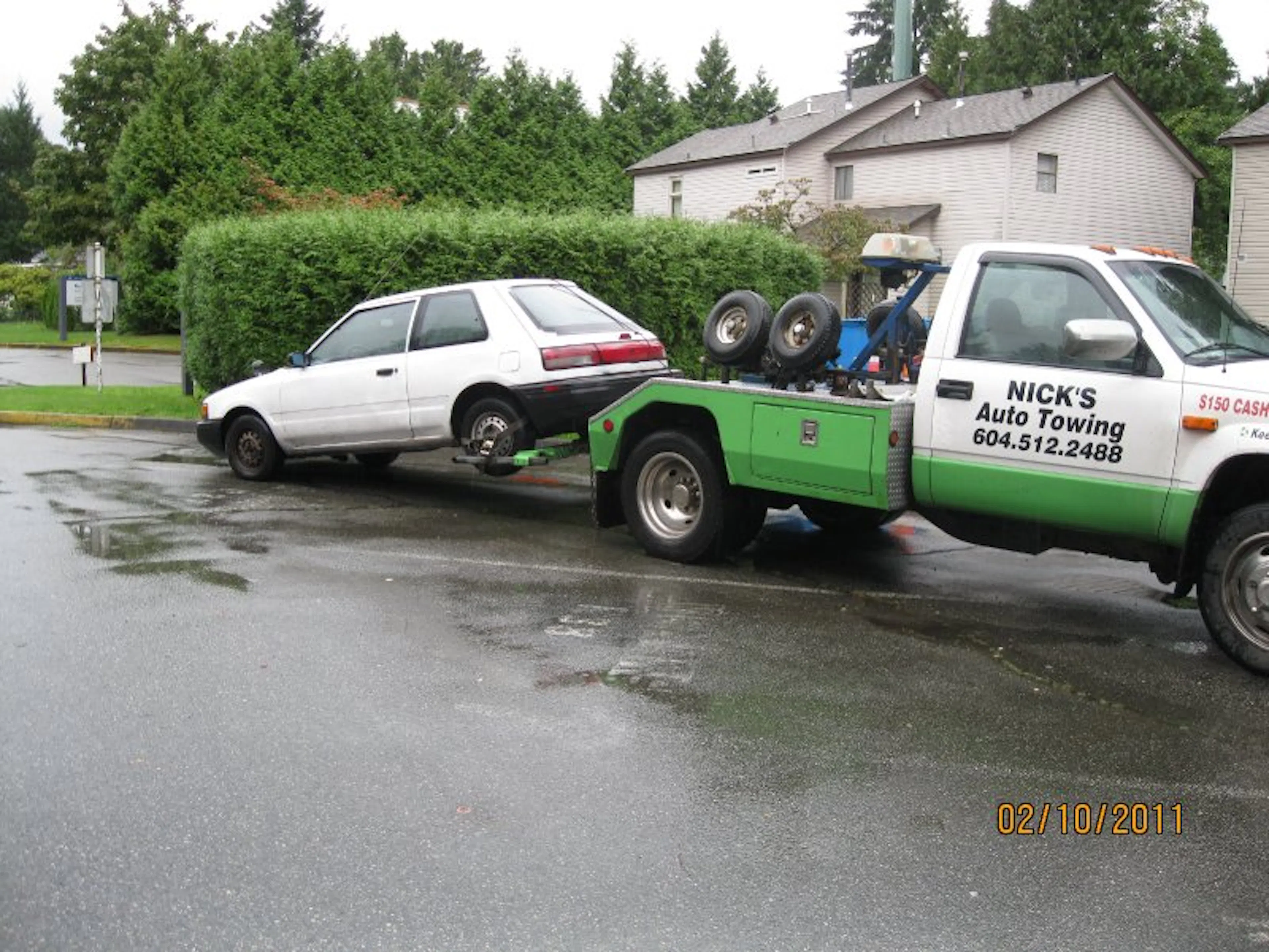 Nick's Auto Towing is picking up a white hatchback in Vancouver.