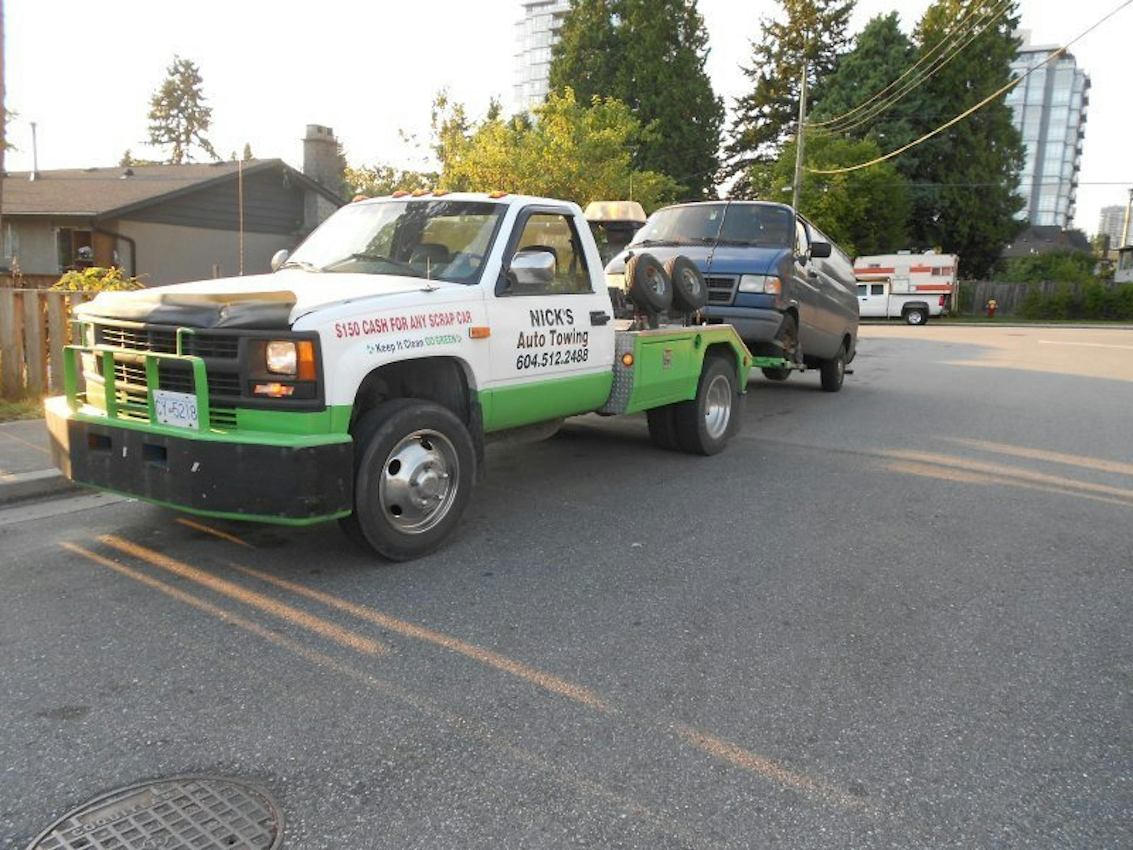 Nick's Auto Towing picking up a Dodge van.