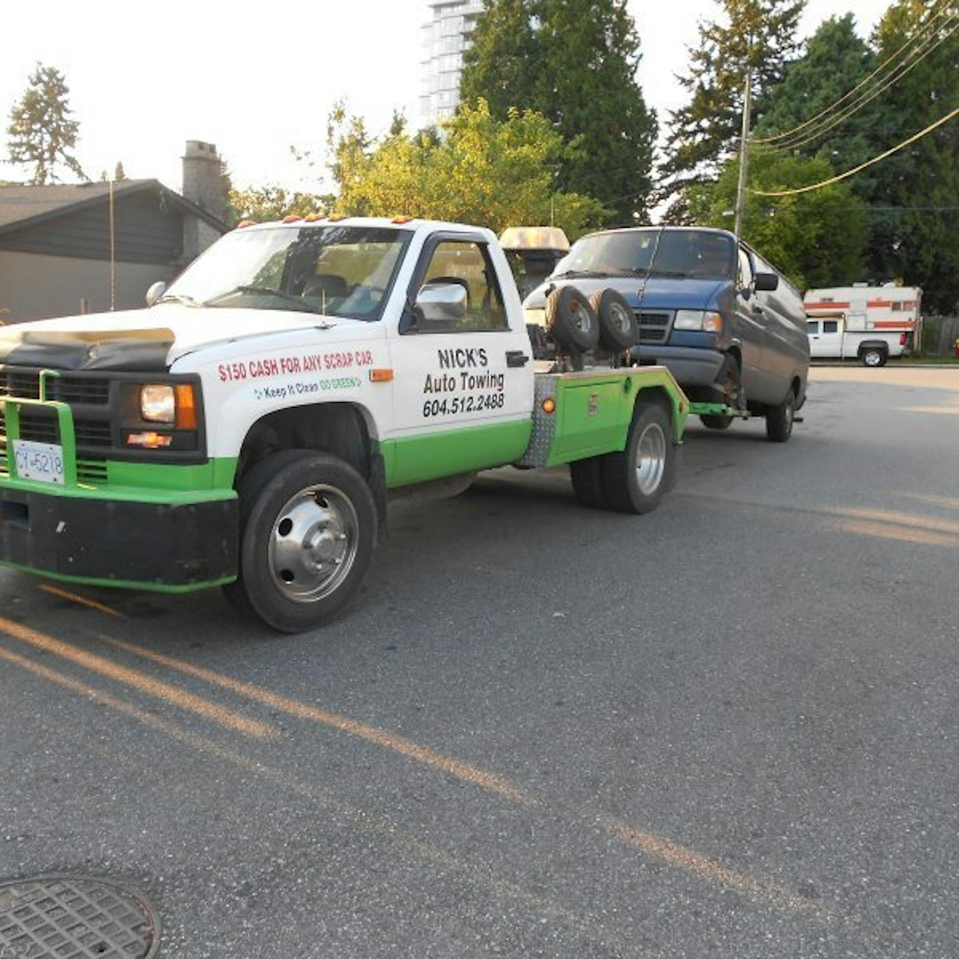 Nick's Auto Towing picking up a Dodge van.