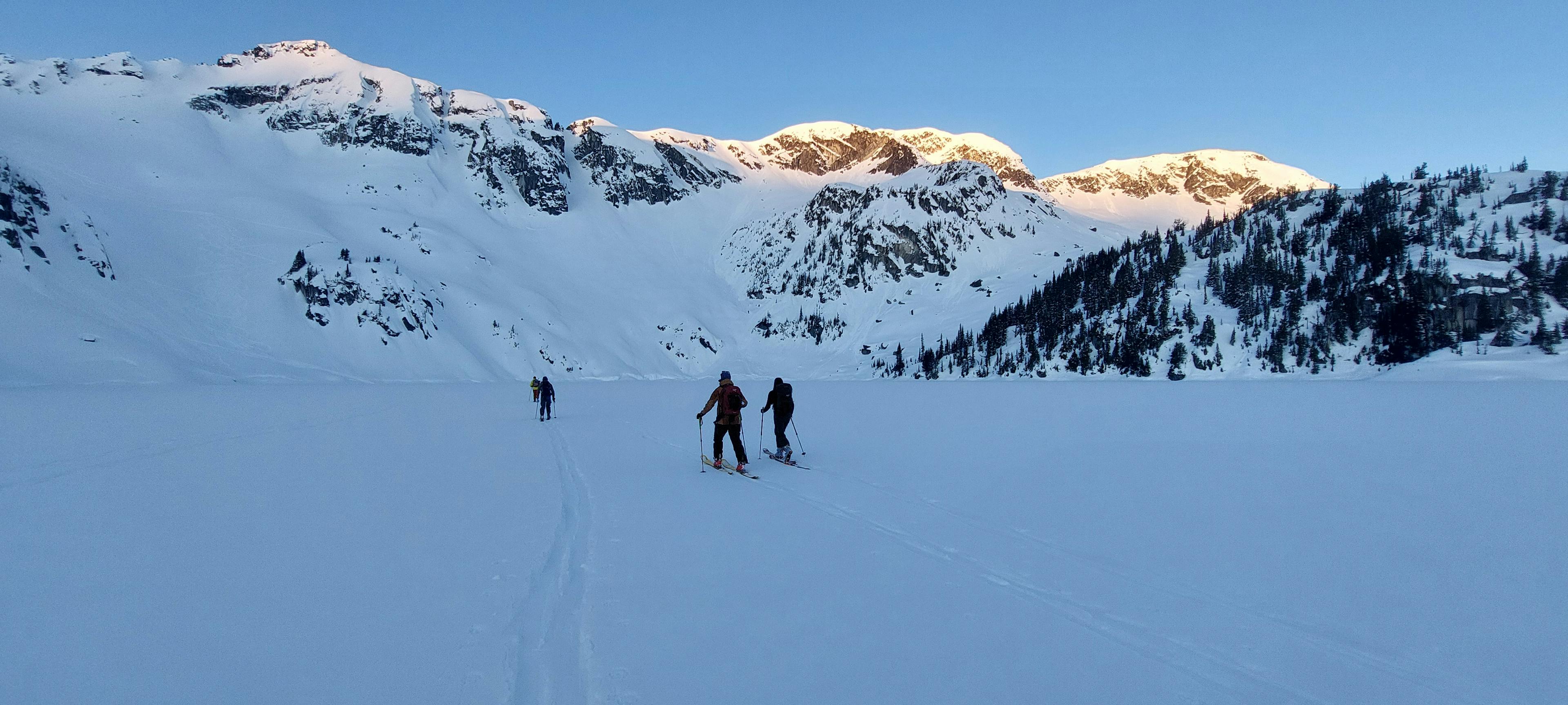 Skiers approaching Marriage Lake at dawn