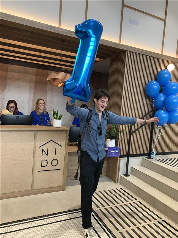 Photo of the first resident at Nido Príncipe Pío with a number 1 balloon