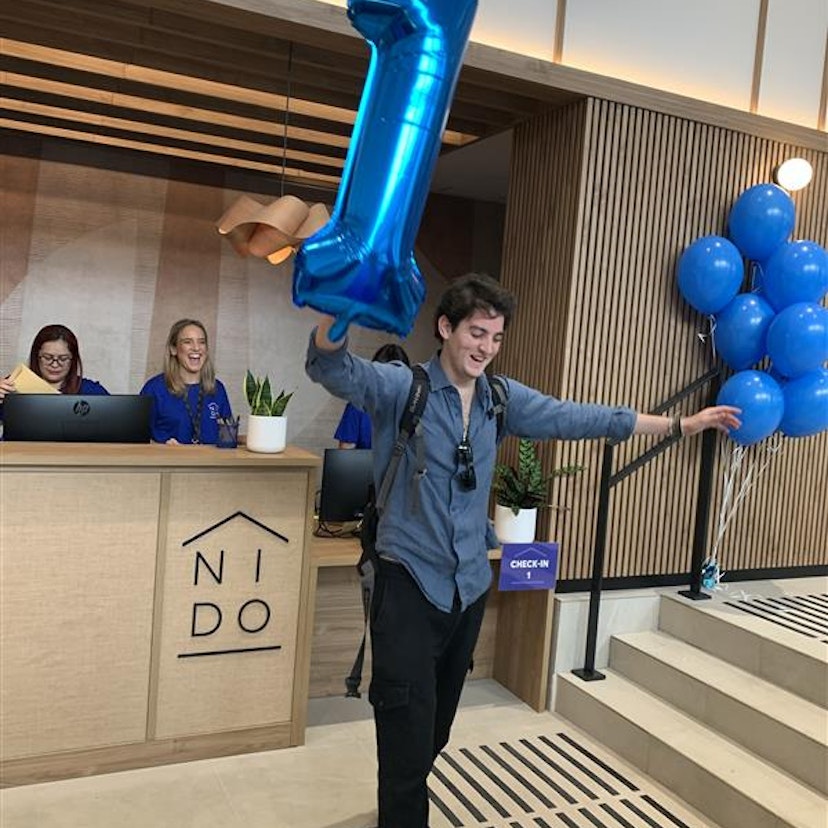 Photo of the first resident at Nido Príncipe Pío with a number 1 balloon