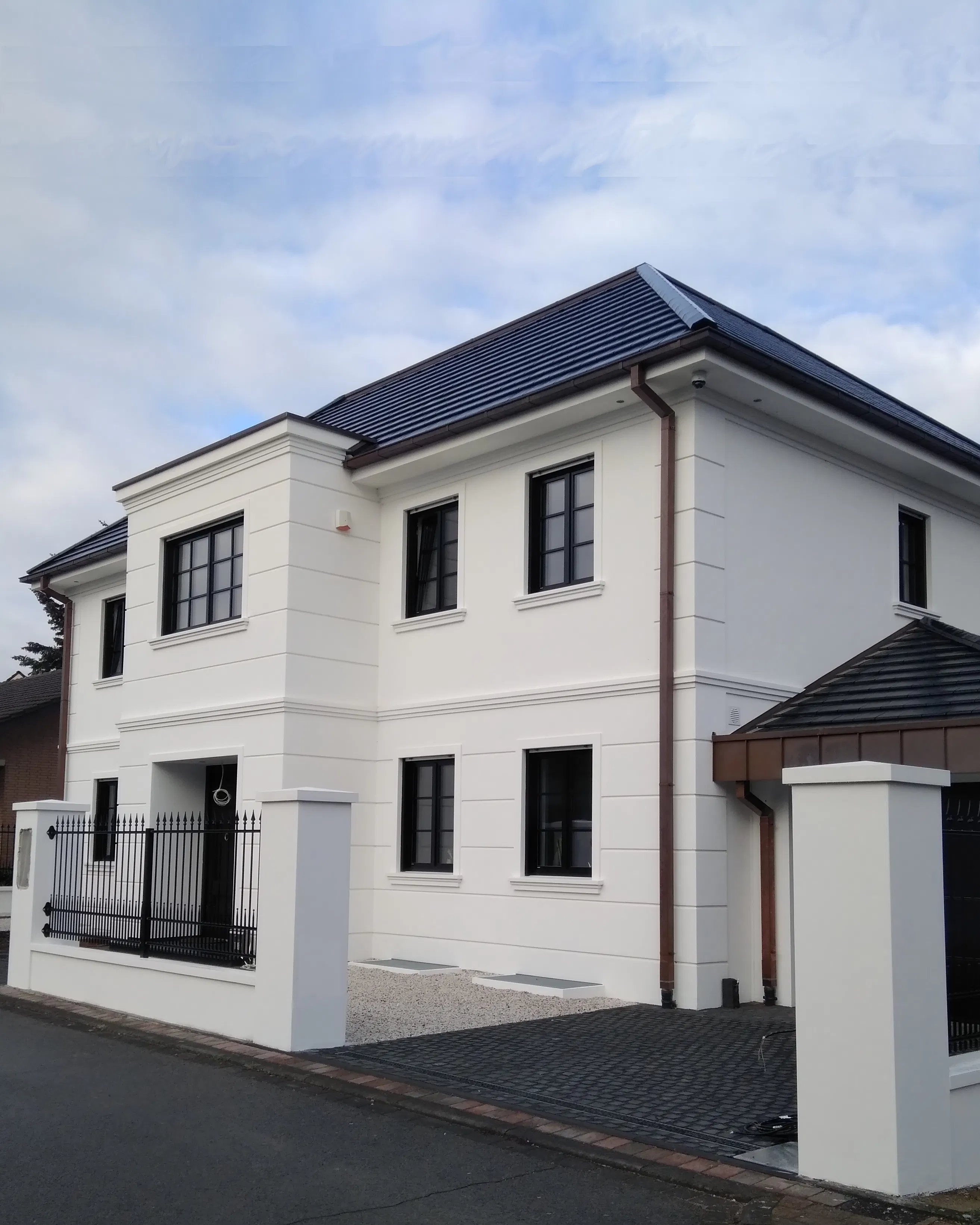 Hochwertige Betonelemente für die Hausfassade und die Aussenanlagen wie Fensterbänke, Mauerabdeckungen, Gesimse, Pfeilerabdeckungen an einer modernen Stadtvilla.