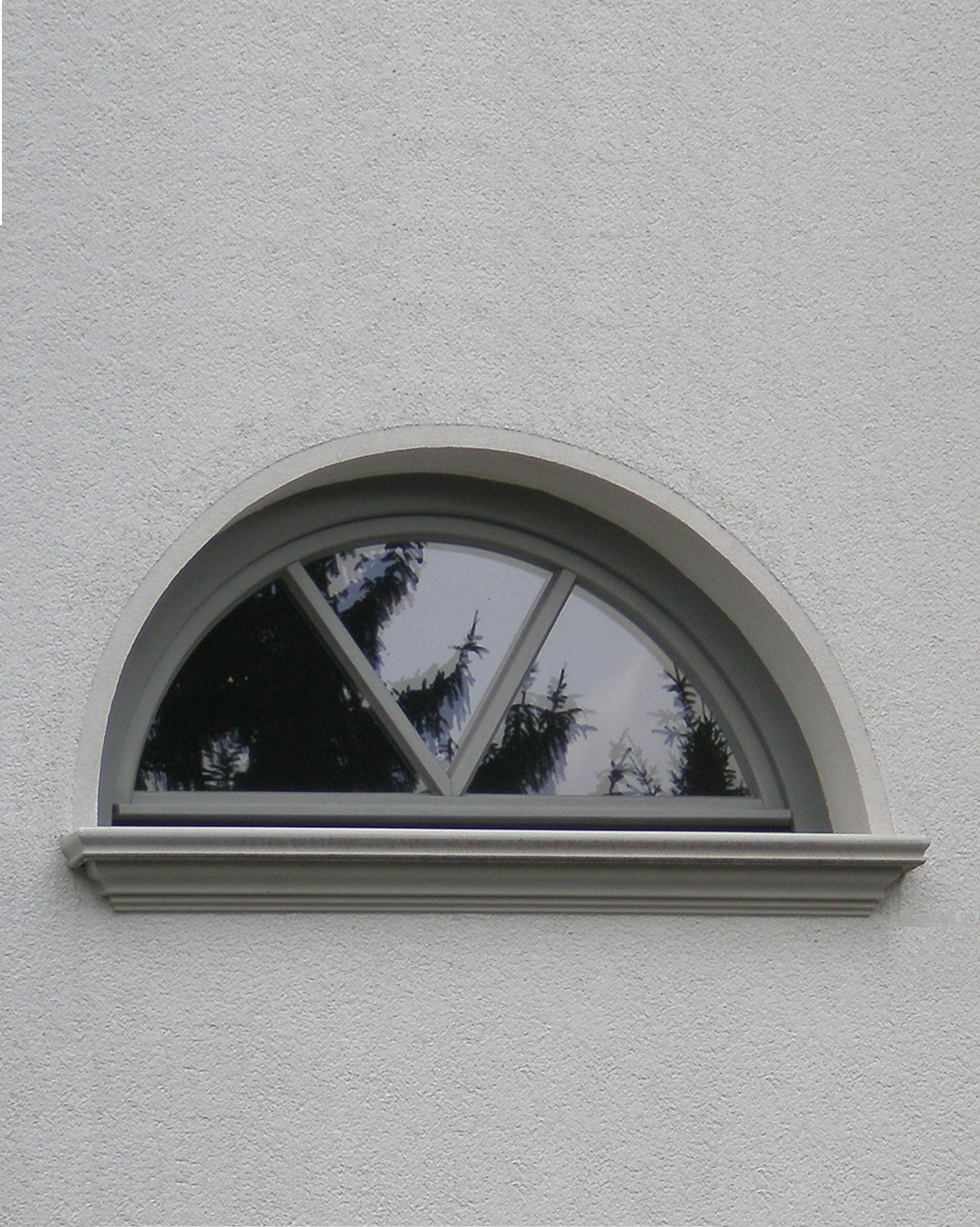 Schön profilierte Zierfensterbank SLB 570 an einem halbrunden Fenster