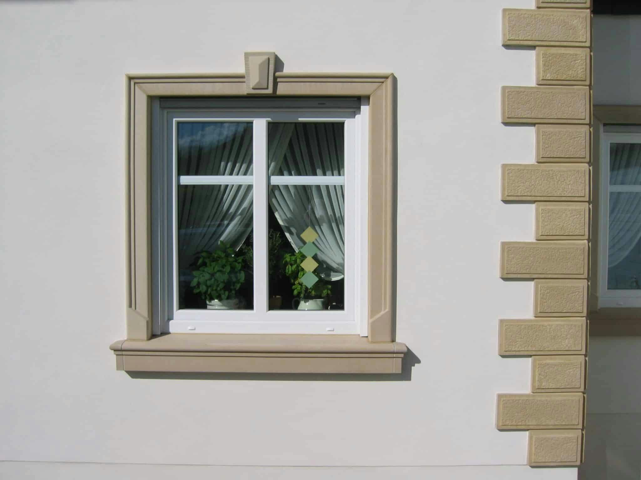 Farblich von heller Fassade abgesetzte Fassadenelemente aus Beton