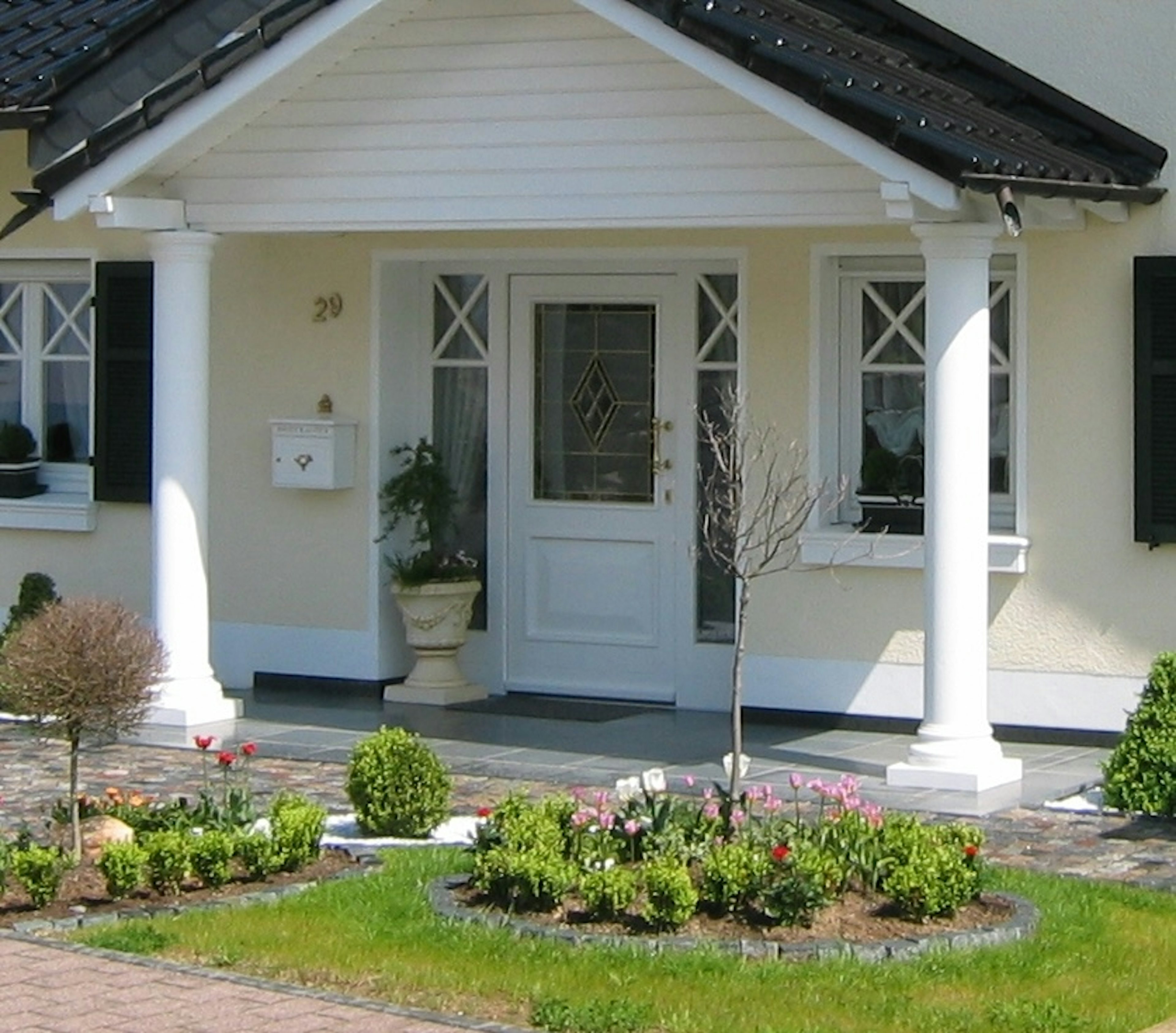 Haus mit zwei Säulen am Eingang unter einem Vordach