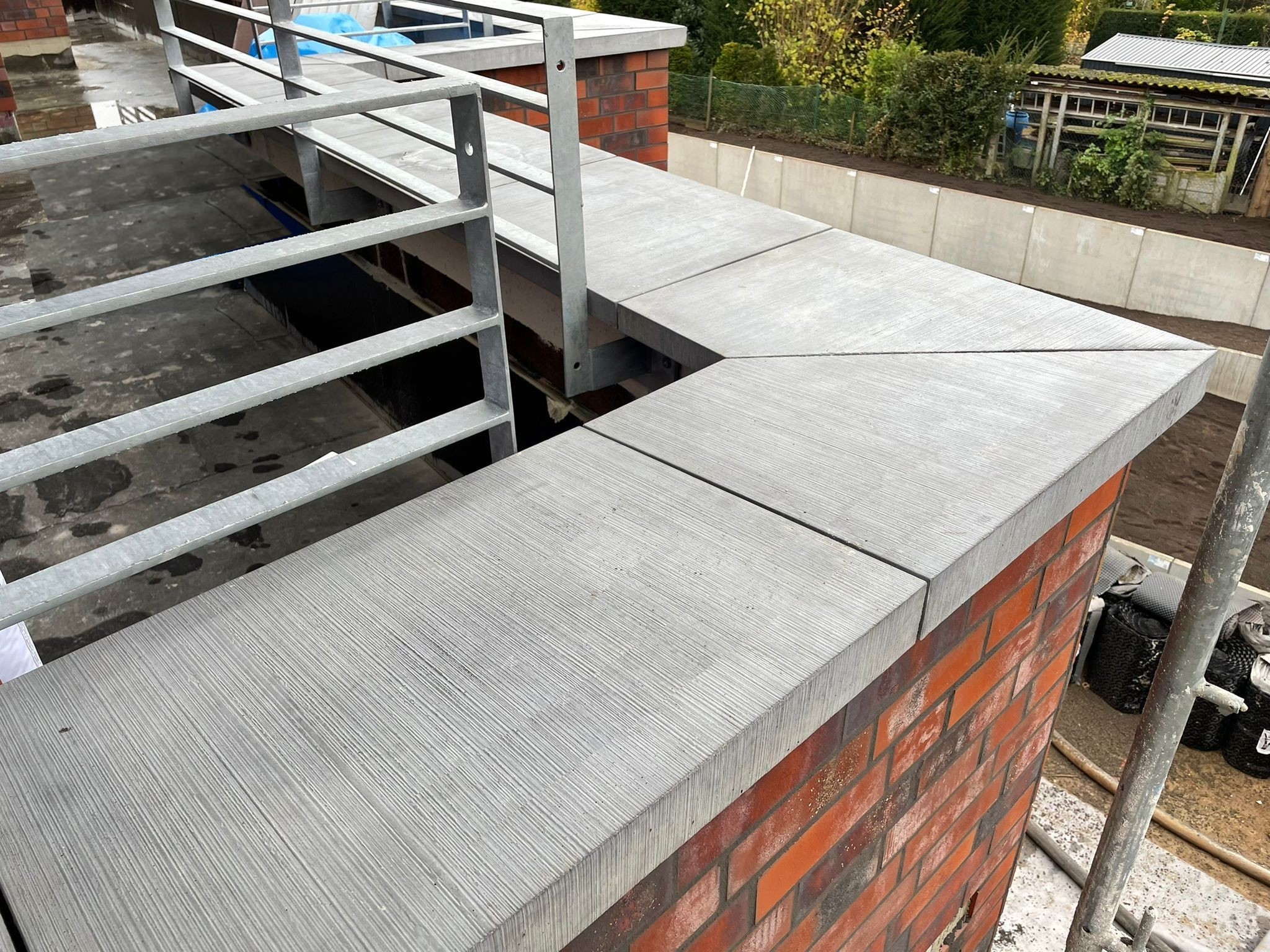 Pultdachförmige Mauerabdeckung von Niessen Beton über Eck