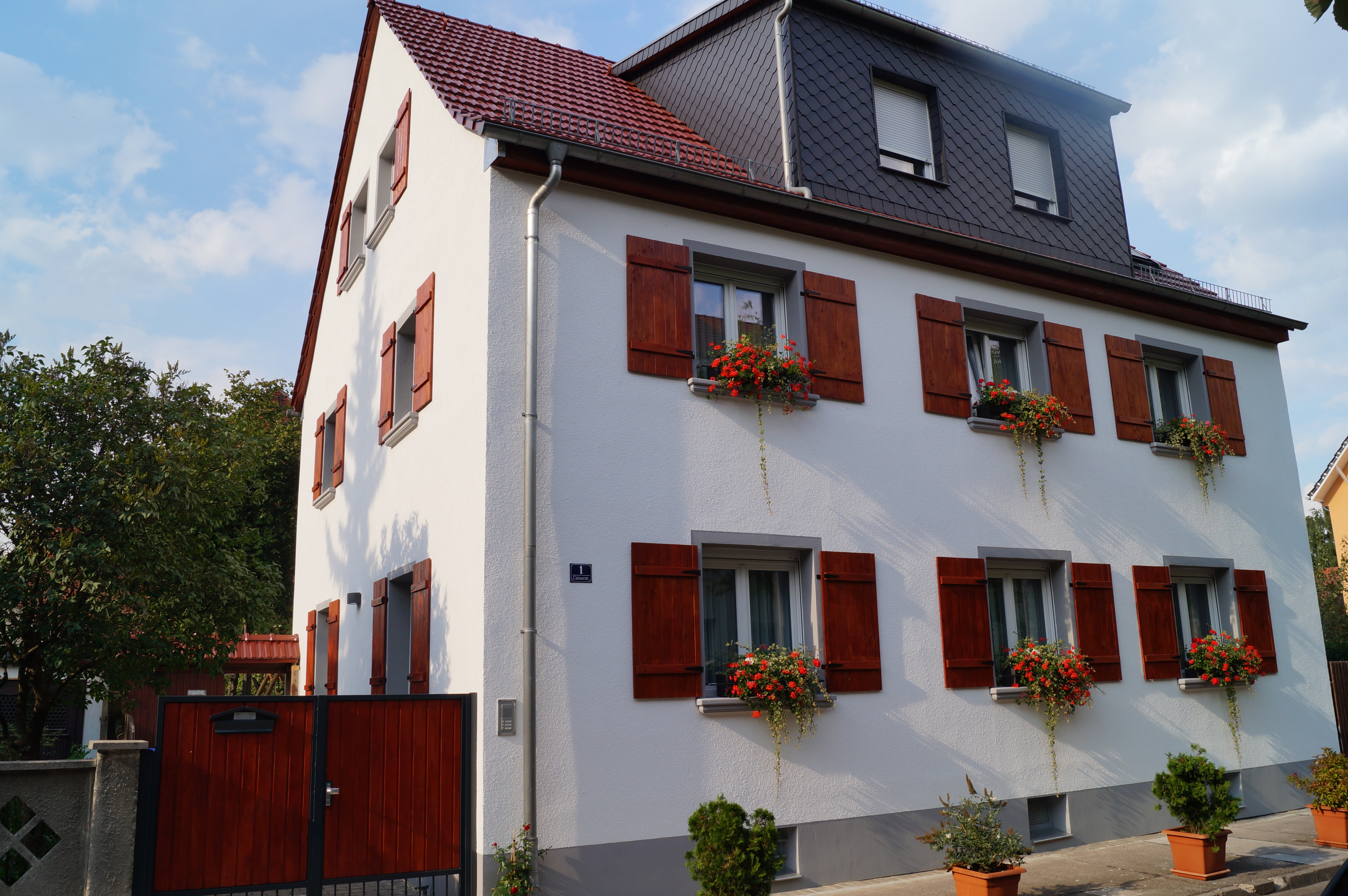 Fenster mit Fensterbänken SLB 200, Klappläden und Blumenschmuck
