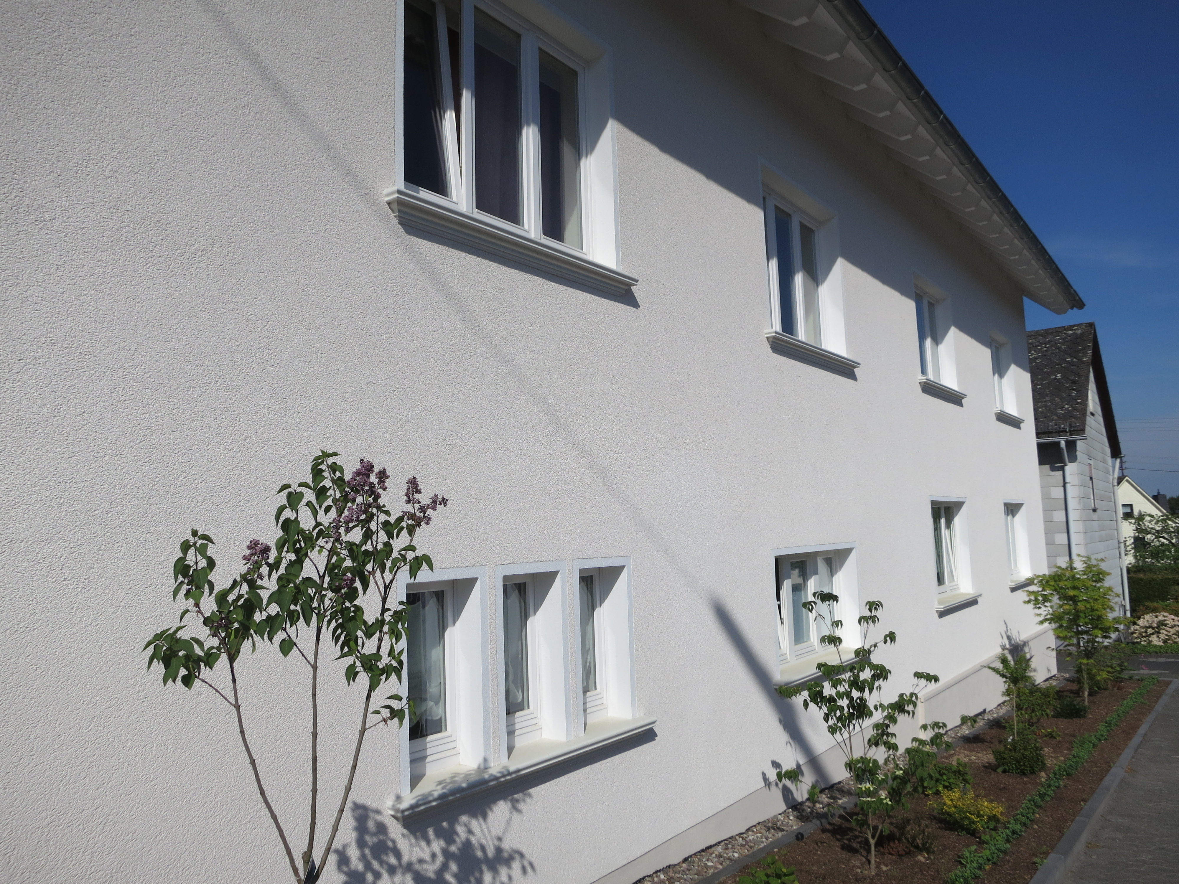 Hell verputzte Hauswand mit Außenfensterbänken SLB 570