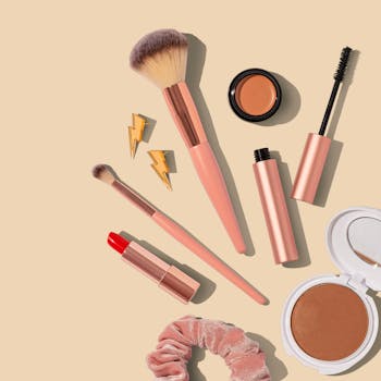 Divers produits de maquillage, notamment des rouges à lèvres et des ombres à paupières, disposés proprement sur un fond beige.