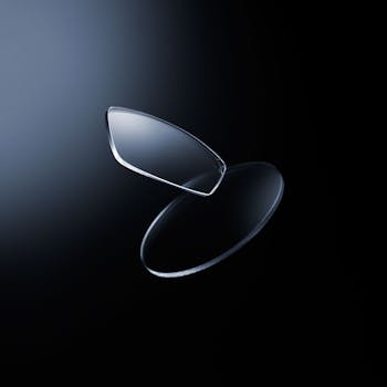 Deux verres optiques Nikon, un verre taillé et un verre non taillé, en suspension sur un arrière-plan sombre.