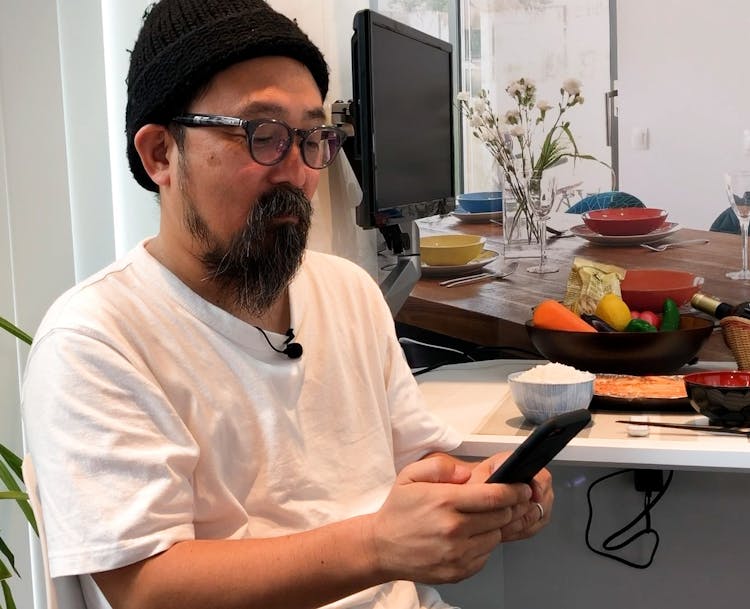 山下監督が携帯を見ている