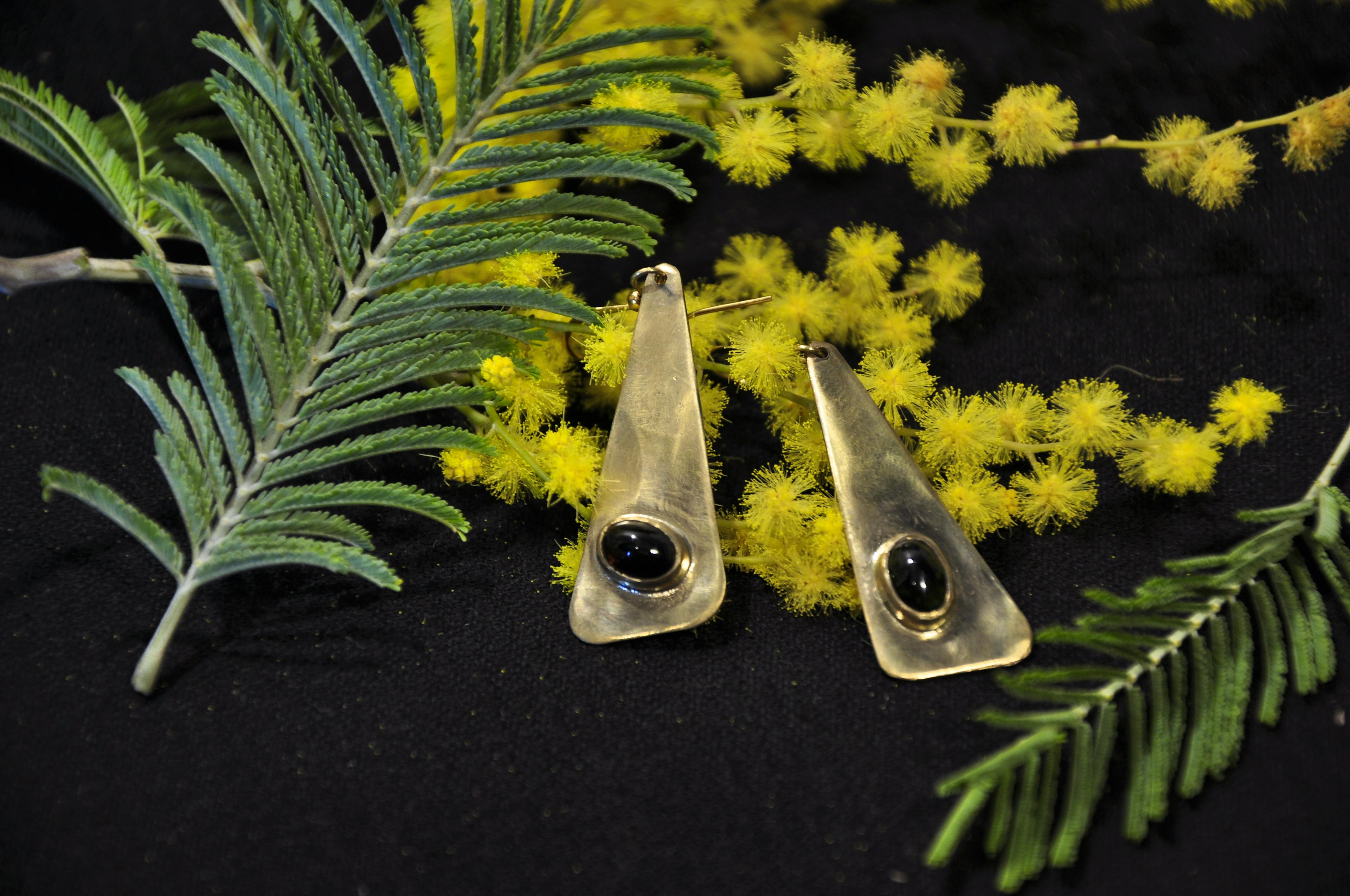 boucles d'oreilles posées sur du mimosa