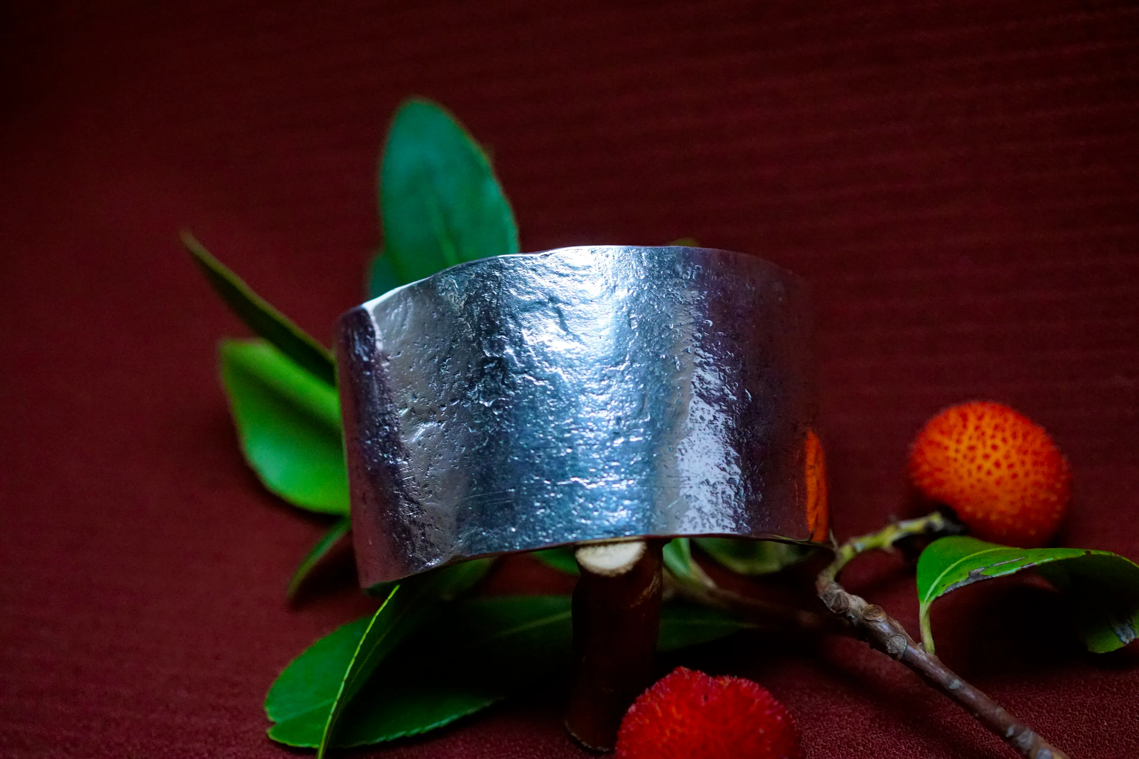 bracelet cuivre et argent posé sur une branche d'arbousié