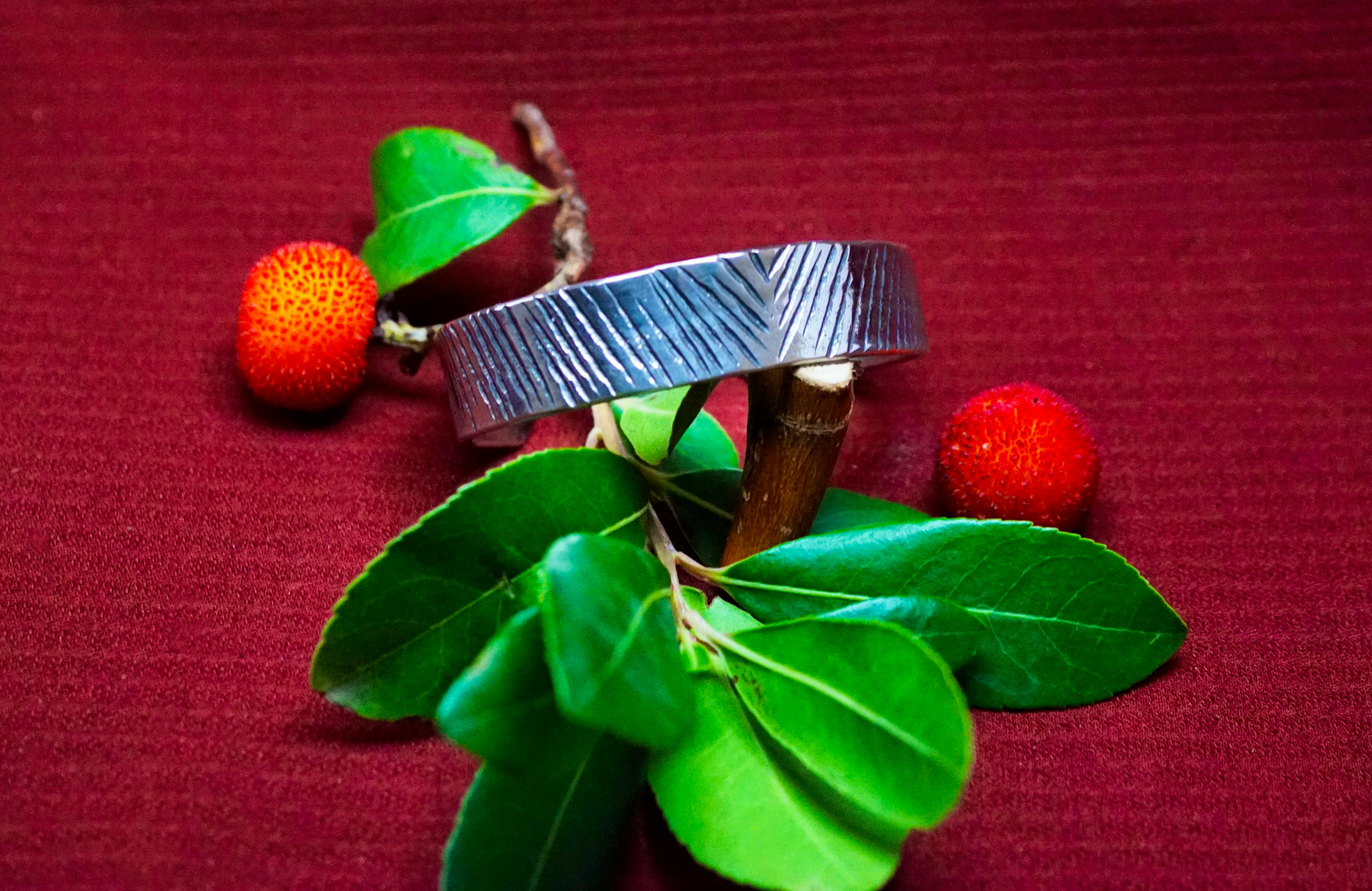 bracelet cuivre et argent posé sur une branche d'arbousié