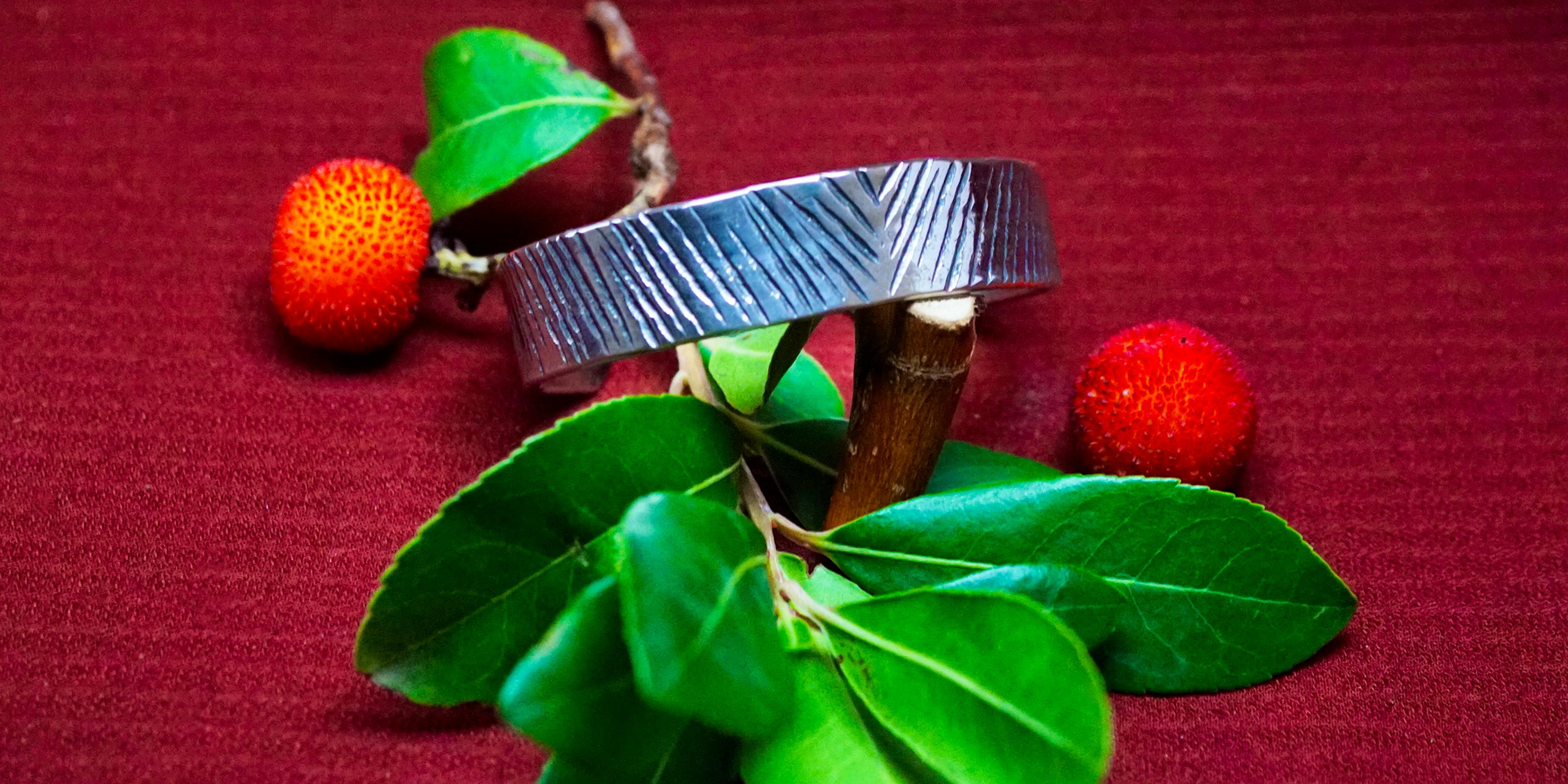 bracelet cuivre et argent posé sur une branche d'arbousié