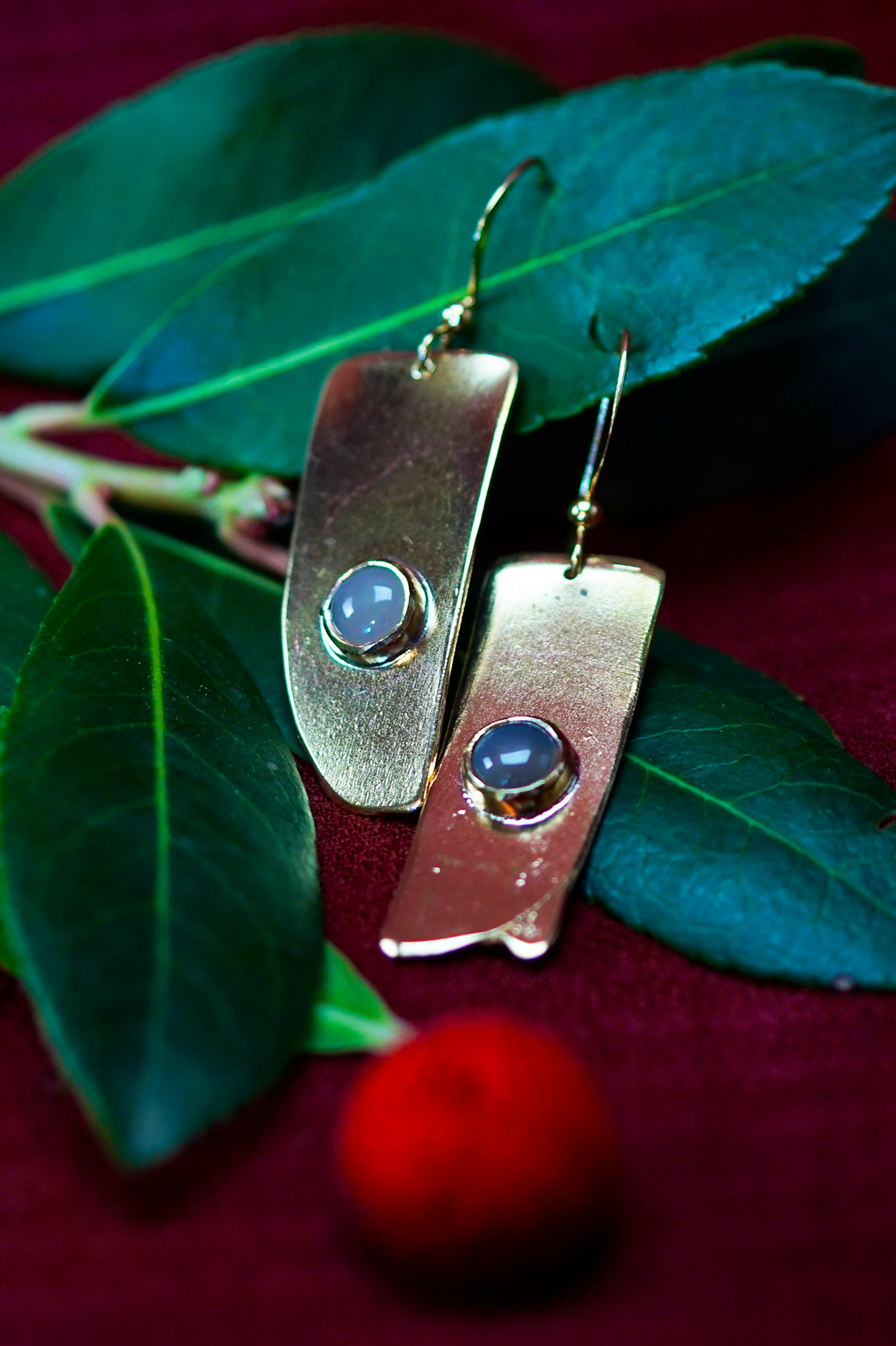 boucles d'oreilles posées sur une branche d'arbousié