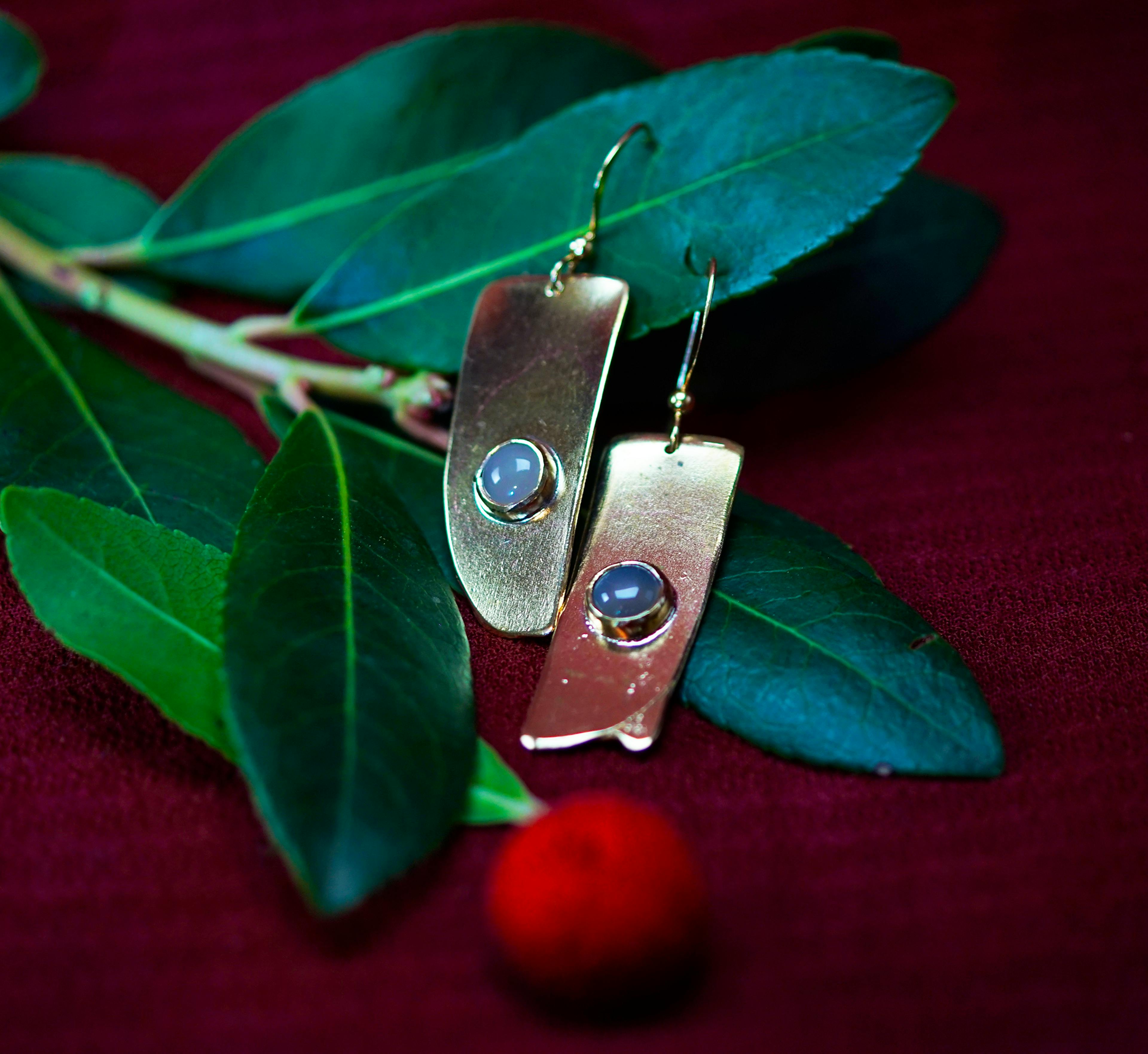 boucles d'oreilles posées sur une branche d'arbousié