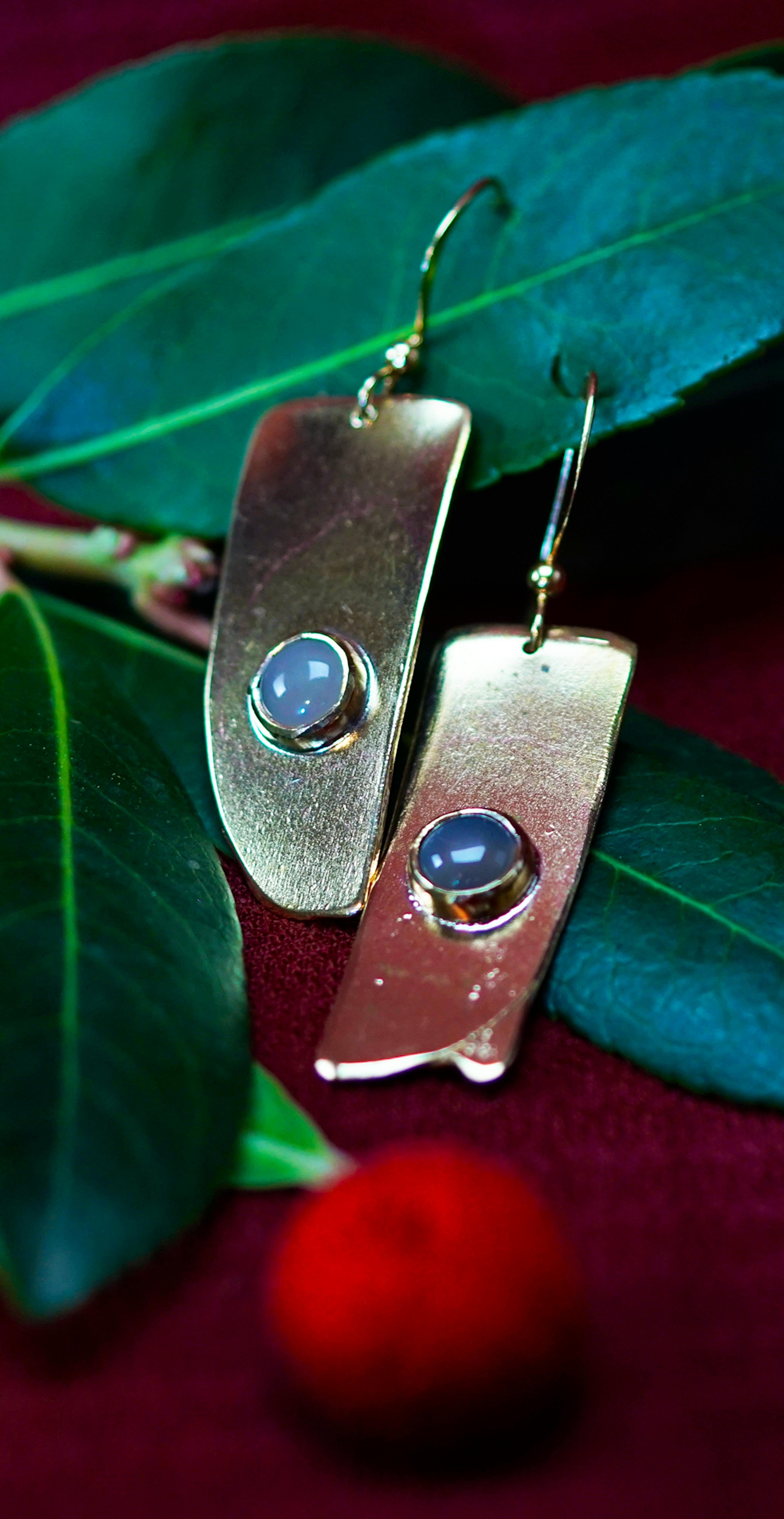 boucles d'oreilles posées sur une branche d'arbousié