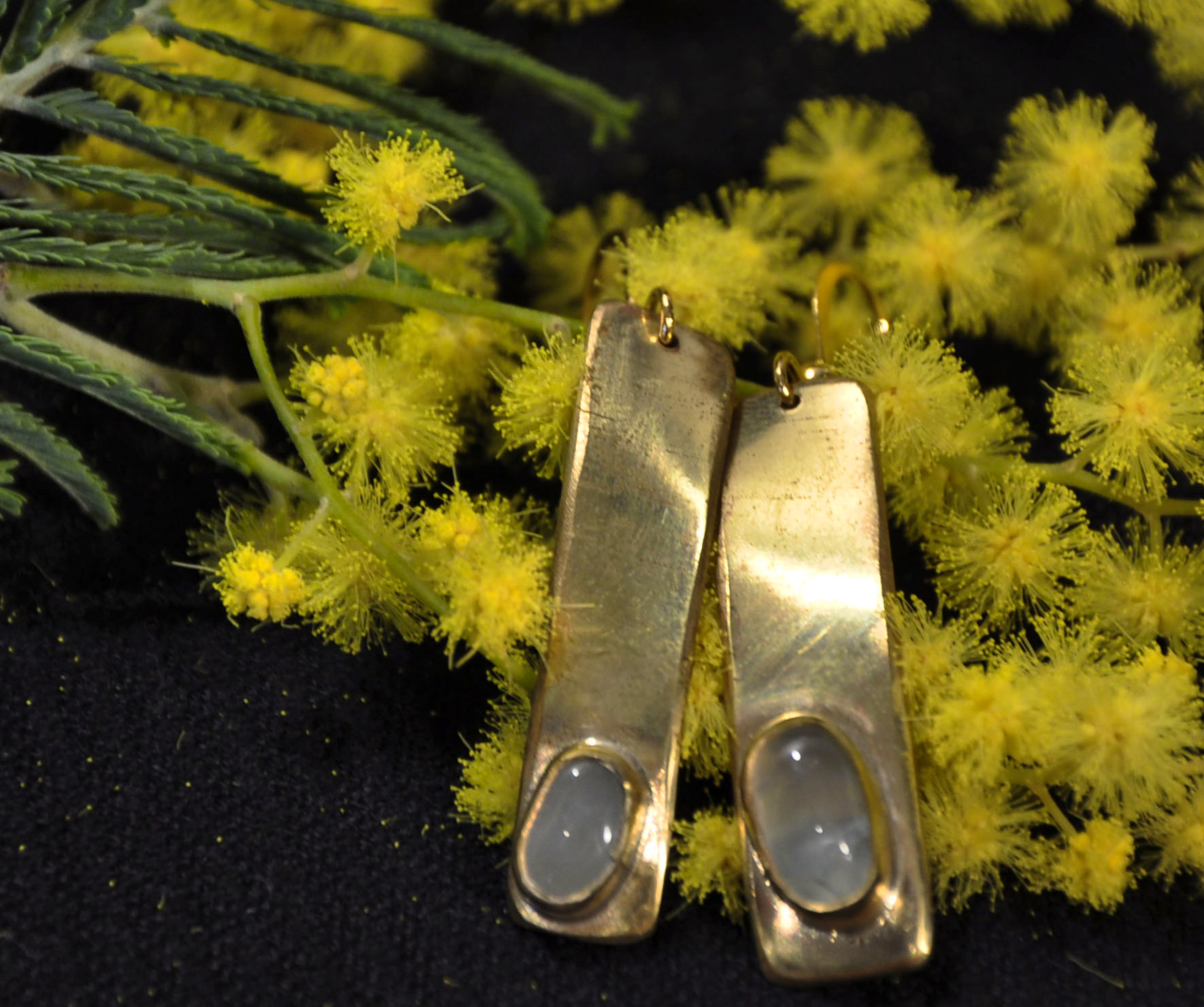 boucle d'oreille posée sur du mimosa