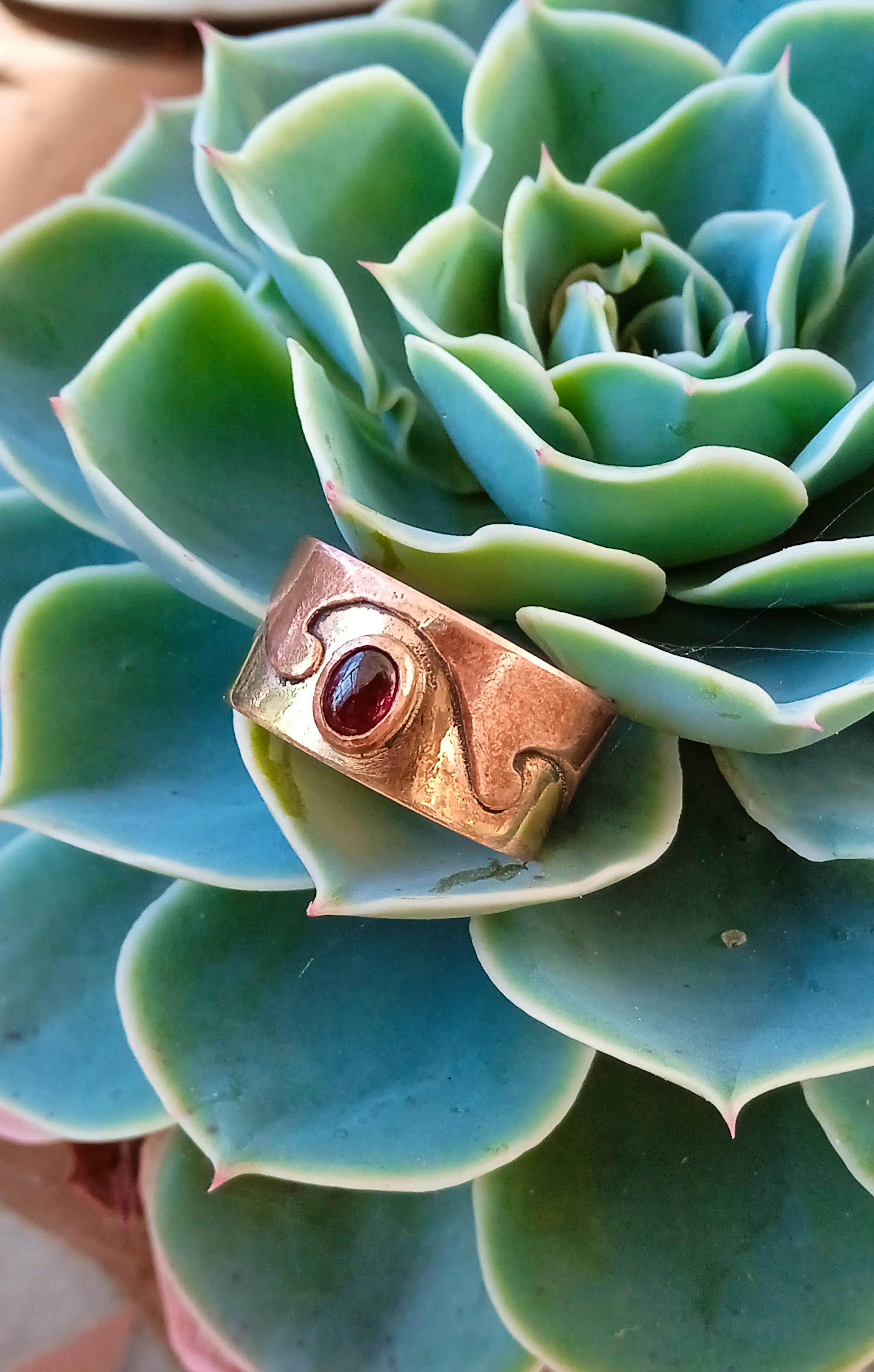 bague laiton cuivre grenat posée sur une racine